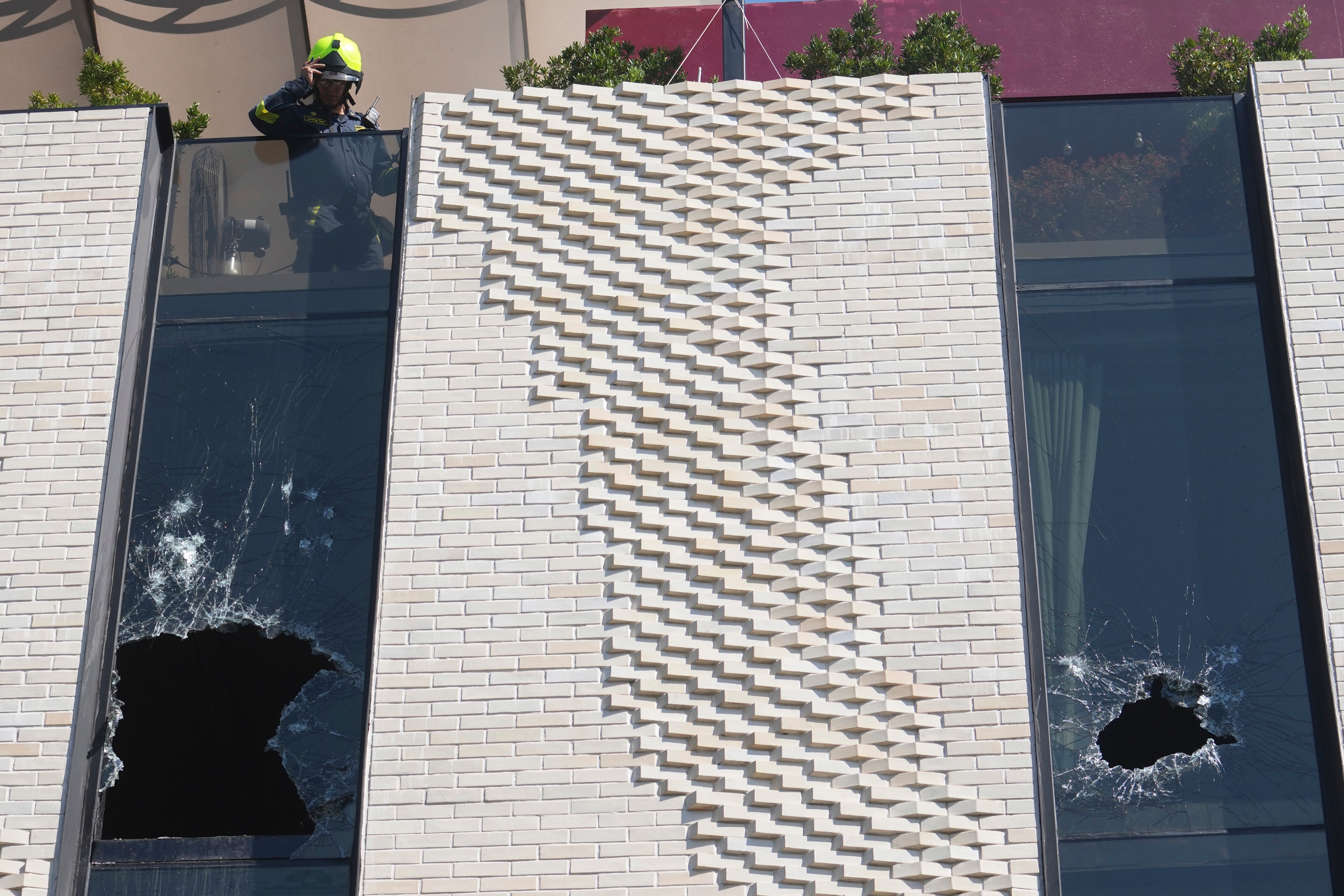 A firefighter checks the broken widows at a hotel in Bangkok, Thailand