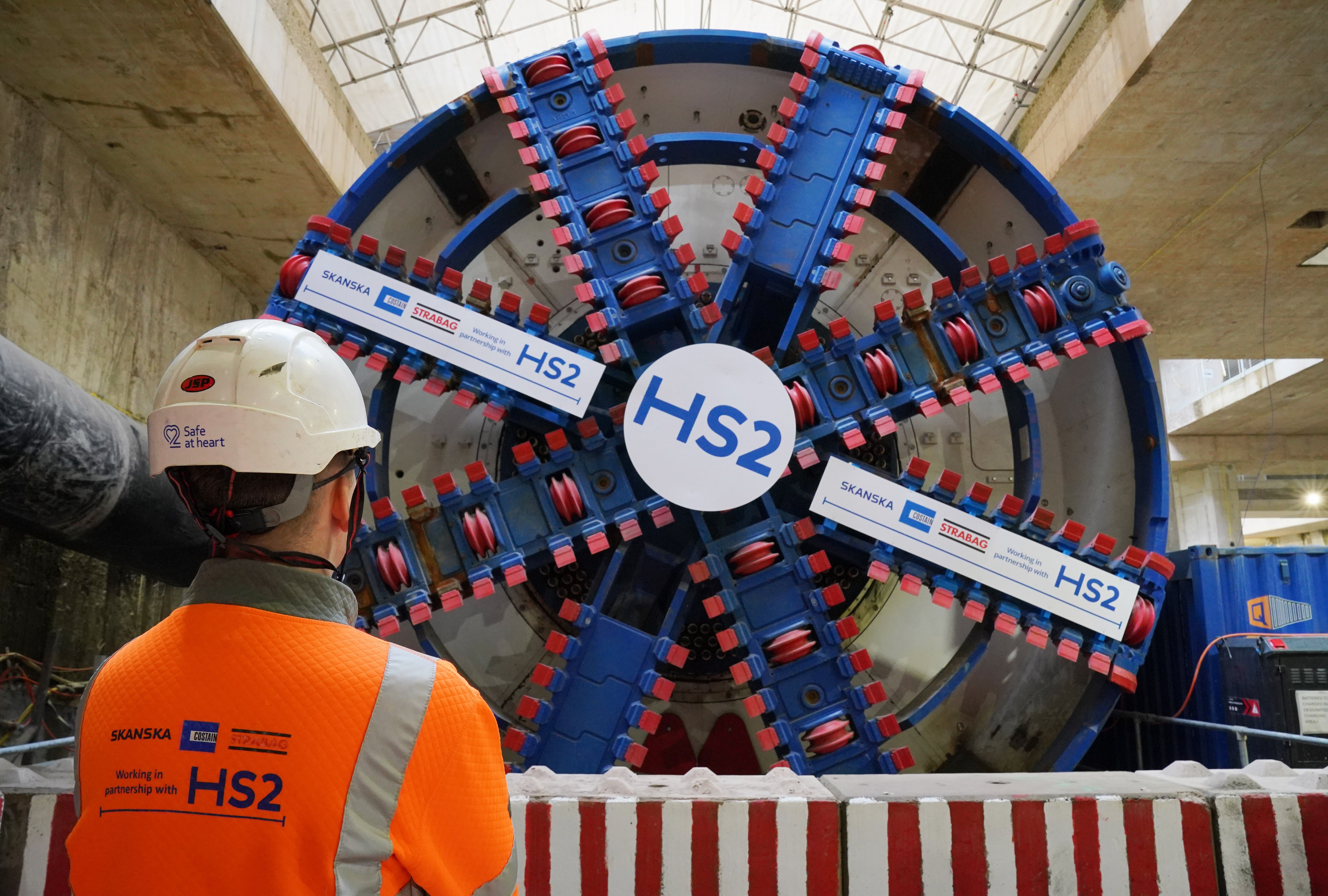 A HS2 worker stands in front of a tunnel boring machine (Jonathan Brady/PA)