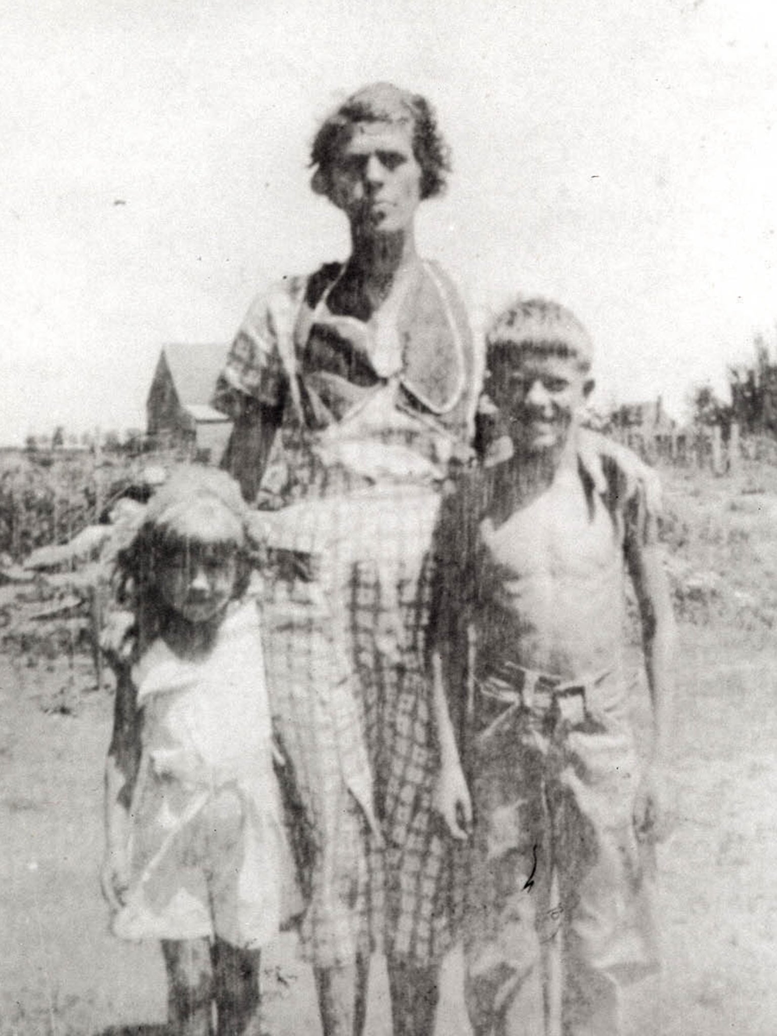 A young Jimmy Carter and sister Ruth stand with their mother, Lillian