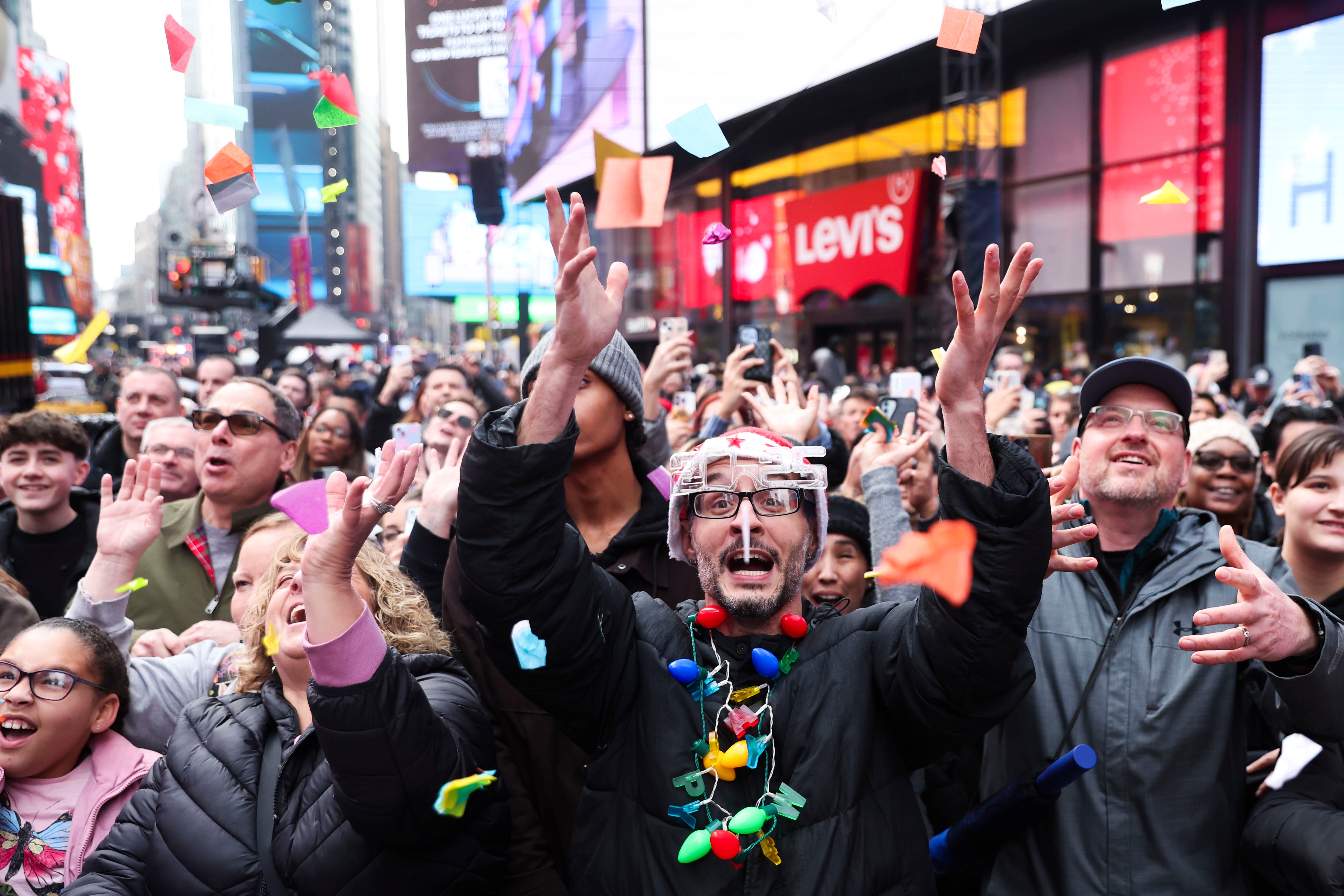 People in the crowd catch confetti ahead of New Year’s Eve in Times Square, Sunday, Dec. 29, 2024,