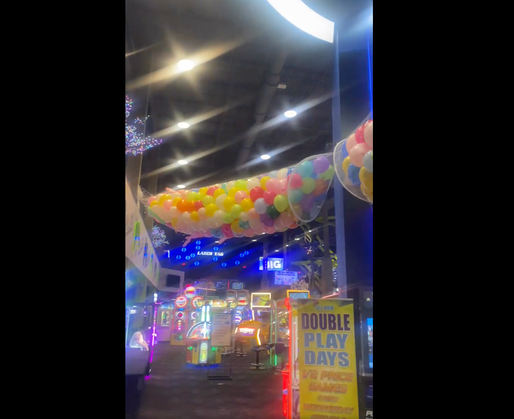 Hundreds of balloons hang in netting over an arcade in Massachusetts