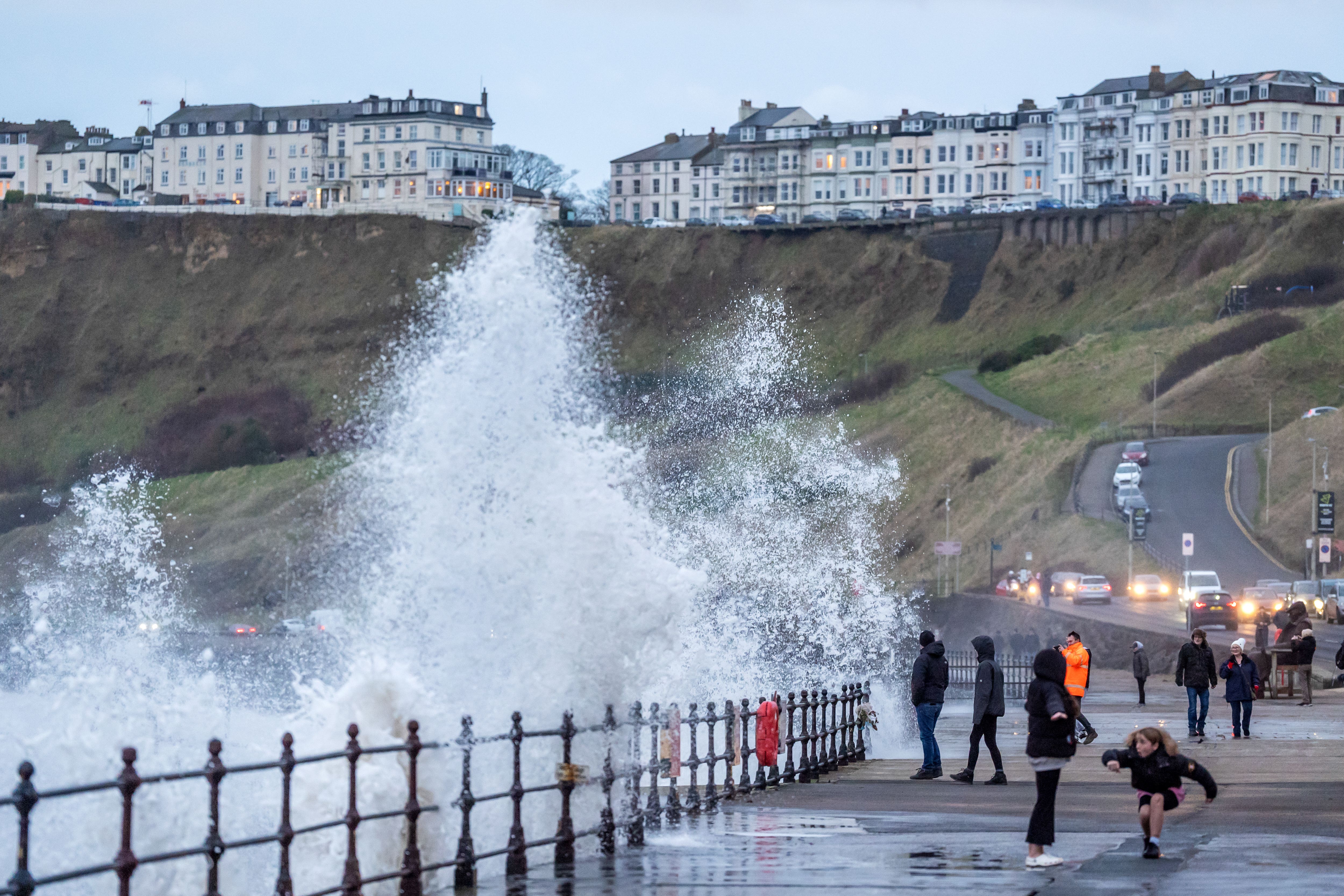 People watch waves crashing in Scarborough, North Yorkshire, as snow, rain and wind warnings are in force (Danny Lawson/PA)