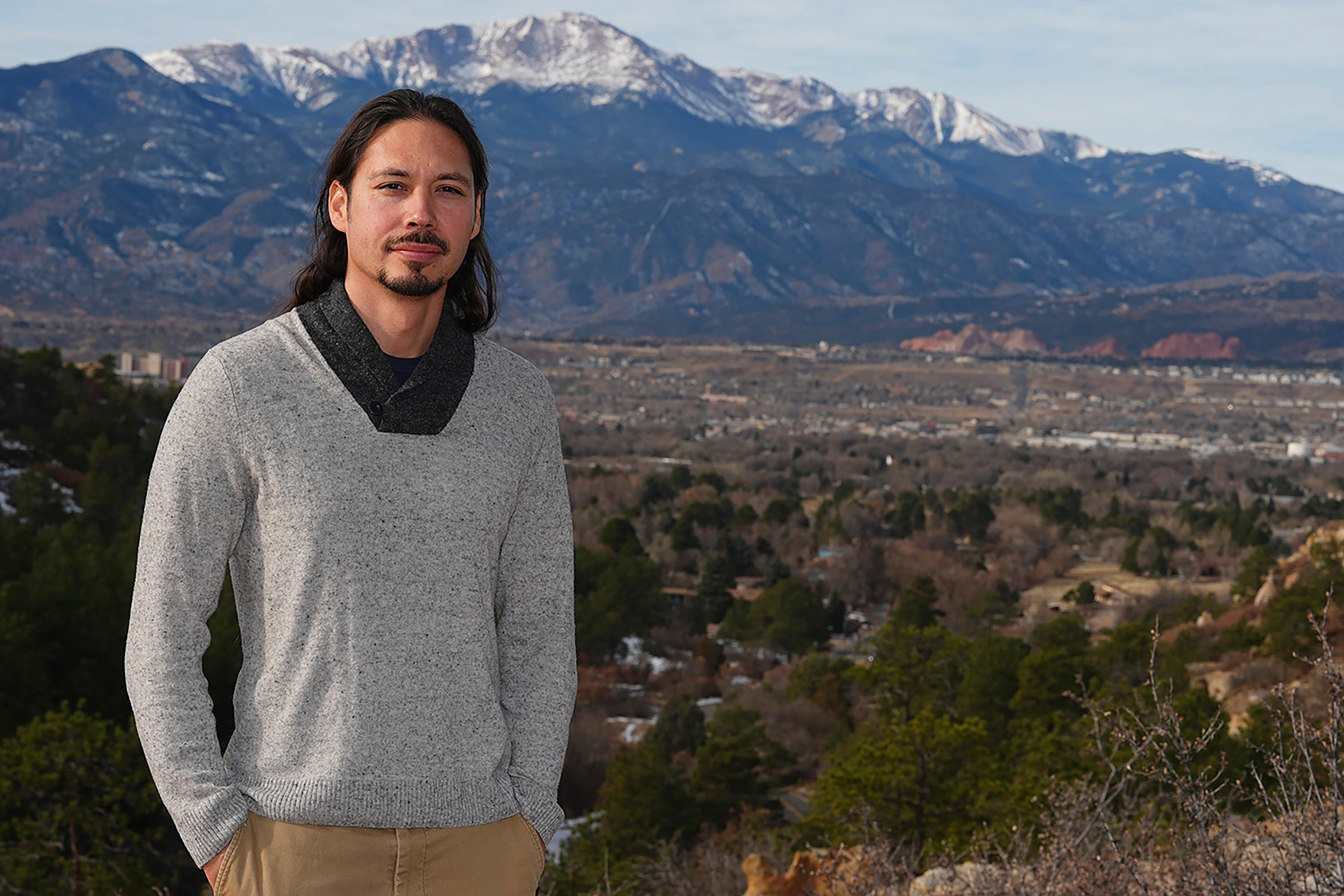 Lane Belone poses with Pikes Peak in the background on an overlook in Palmer Park, Thursday, Dec. 19, 2024, in Colorado Springs, Colorado