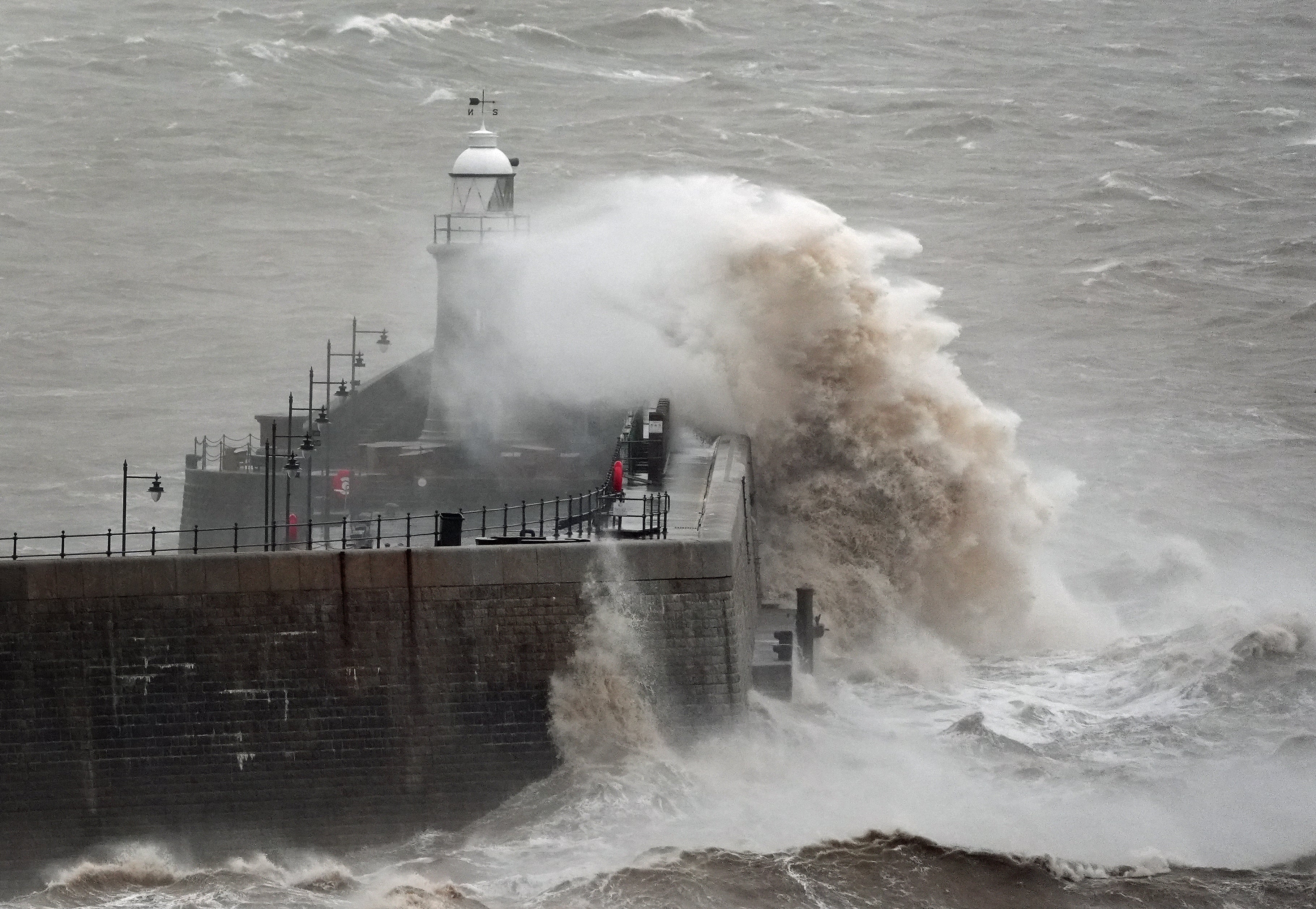 Waves crash against Folkestone harbour wall in Kent, as wind, rain and snow warnings are in force across parts of the UK