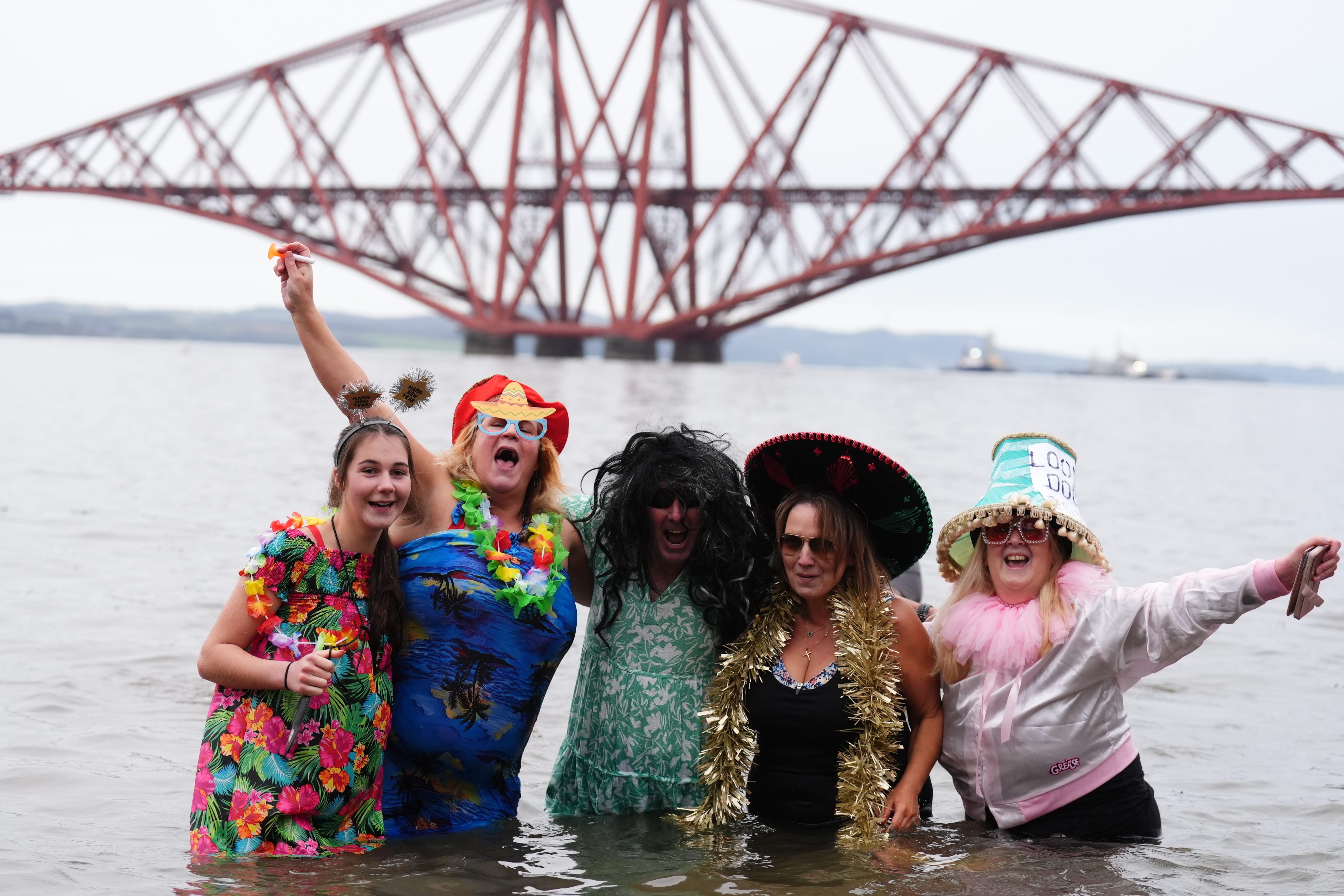 People take part in the Loony Dook New Year’s Day dip in the Firth of Forth at South Queensferry, as part of Edinburgh’s Hogmanay celebrations (Andrew Milligan/PA)