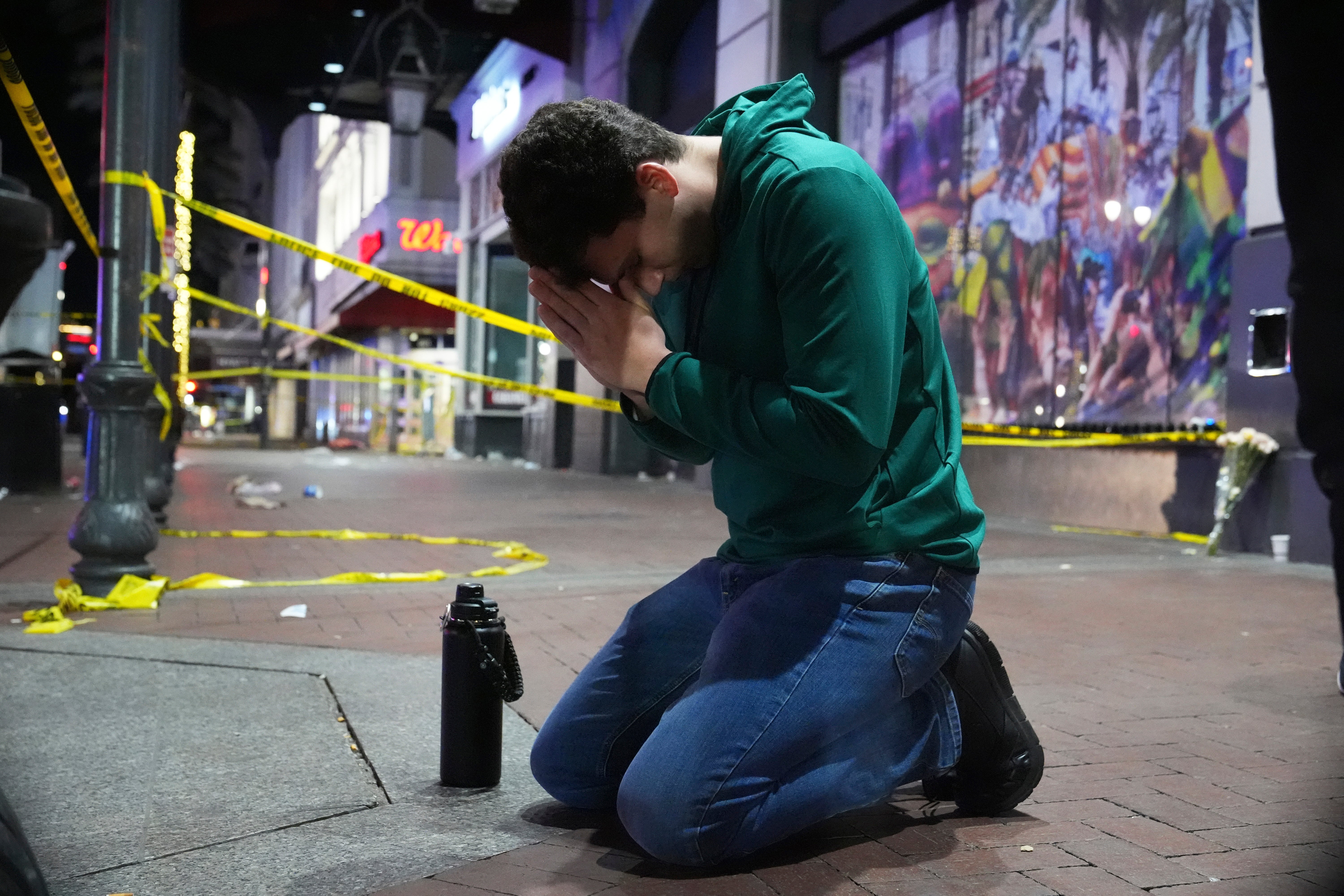 Matthias Hauswirth of New Orleans prays on the street near the scene where a vehicle drove into a crowd