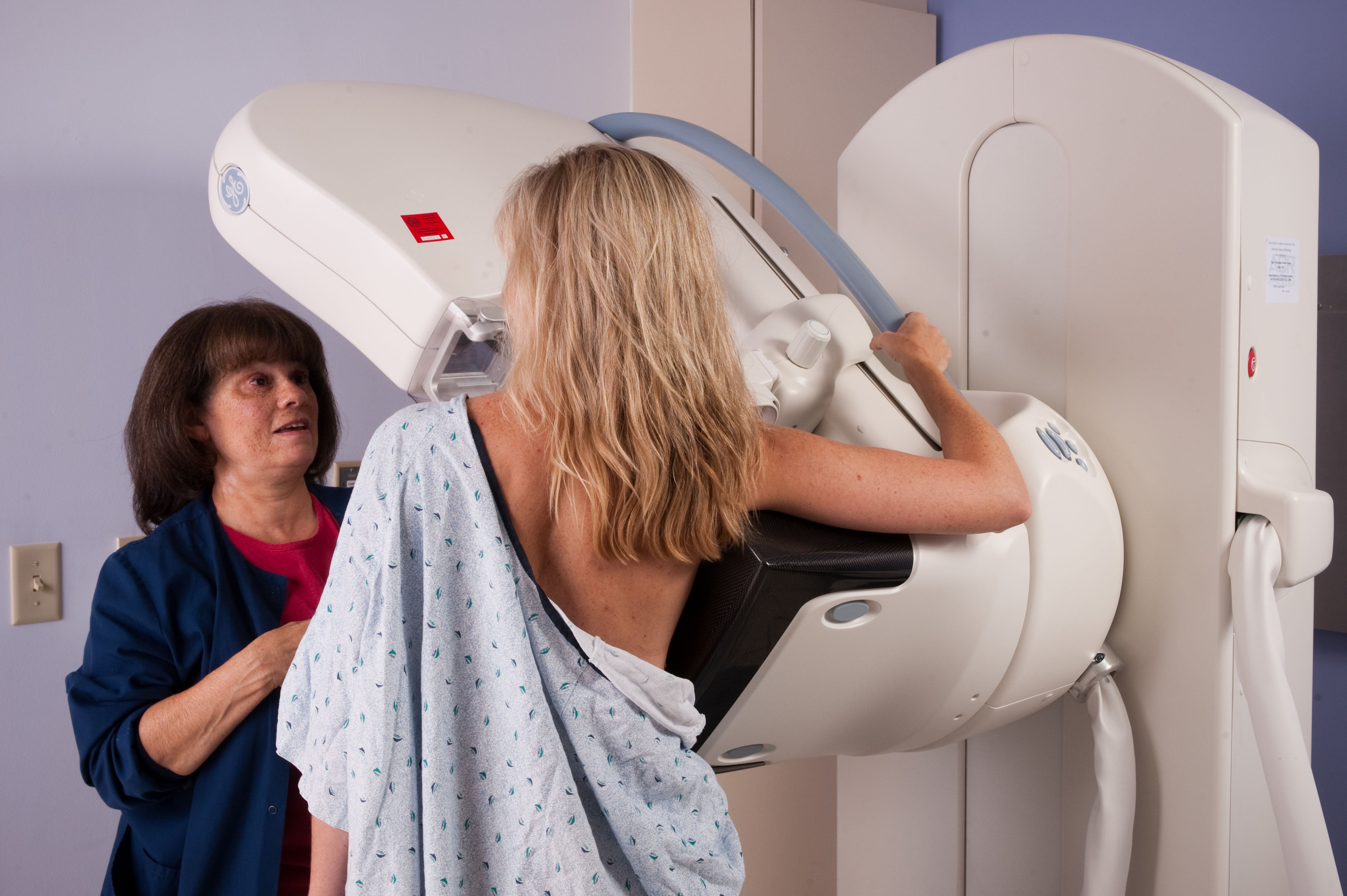 A nurse helping a patient during a digital mammogram