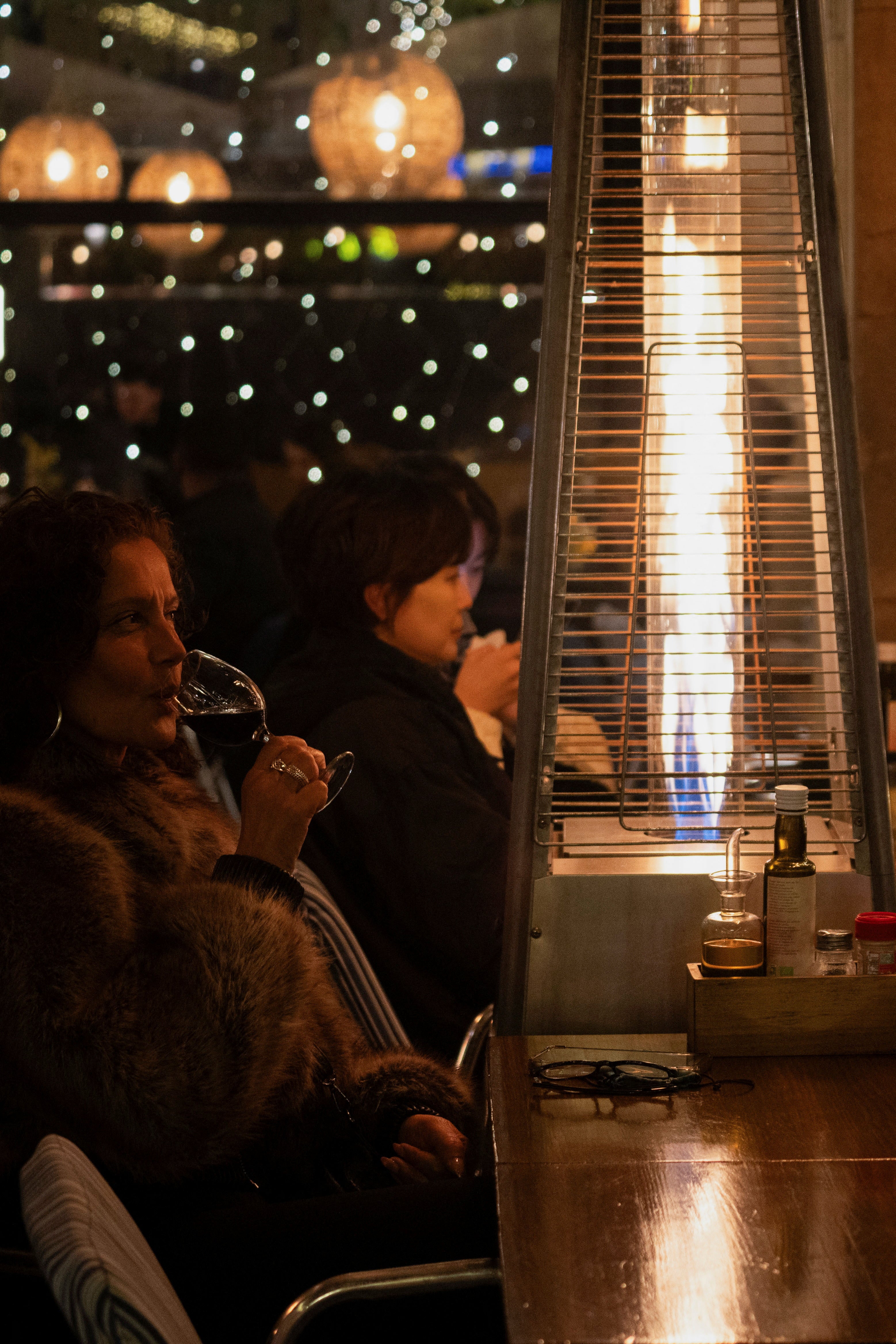 Tourists sit on a restaurant terrace as they shelter from the cold with gas heaters, which will be banned due to CO2 emissions from the first day of the new year, in Reial Square of Barcelona, Spain December 29, 2024