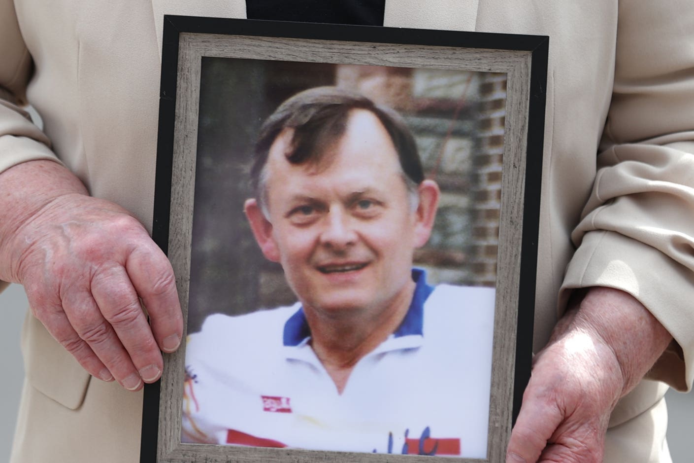 Bridie Brown, the widow of murdered GAA official Sean Brown, holds a picture of him (PA)