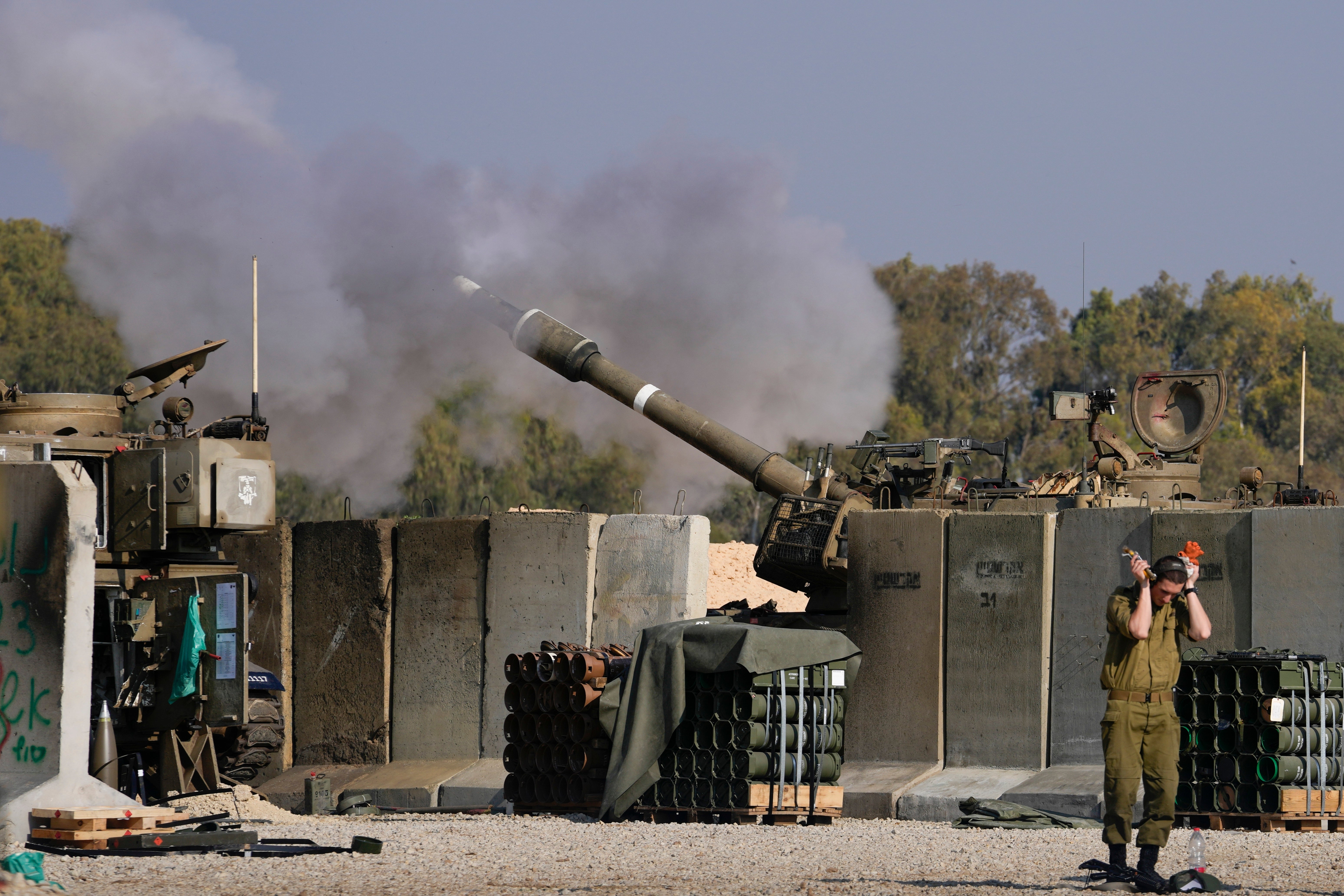 An Israeli soldier covers his ears as an artillery gunner fires into the Gaza Strip from a position in southern Israel on 2 January2025