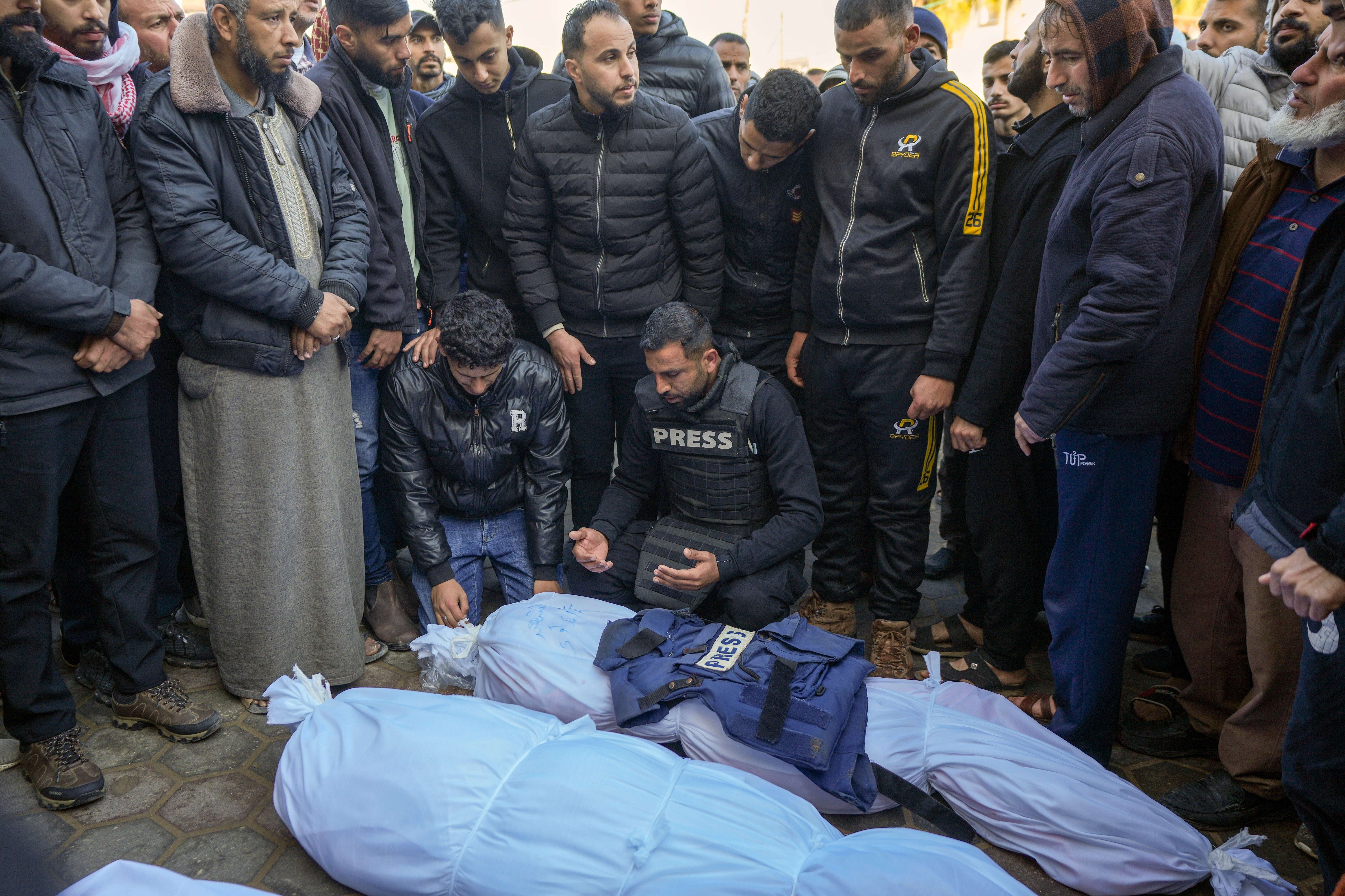 Colleagues and friends mourn over the body of freelance journalist Omar al-Derawi and other victims of overnight Israeli army strikes at multiple locations in central Gaza Strip, at Al-Aqsa Martyrs Hospital in Deir al-Balah, Friday, Jan. 3, 2025.