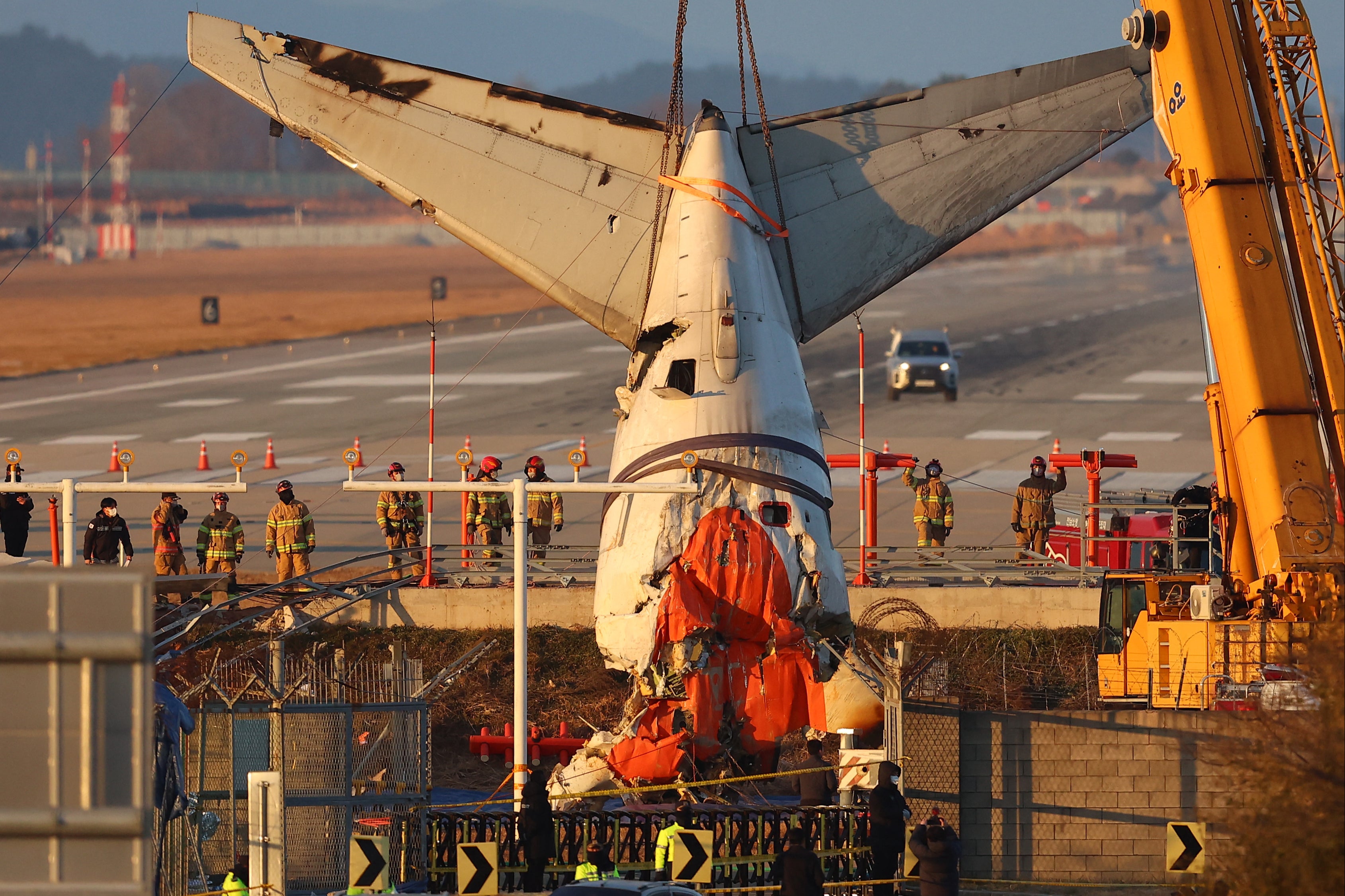 A crane lifts the tail section during the salvage operation of the Jeju Air Boeing 737-800 aircraft which crashed and burst into flames at Muan International Airport, in Muan on 3 January 2025