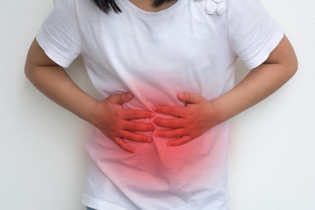 <p>A child holds her hands up to press on her stomach. More children around the US are getting kidney stones, which can cause sharp pain in the lower abdomen. The increase is especially notable in adolescent girls </p>