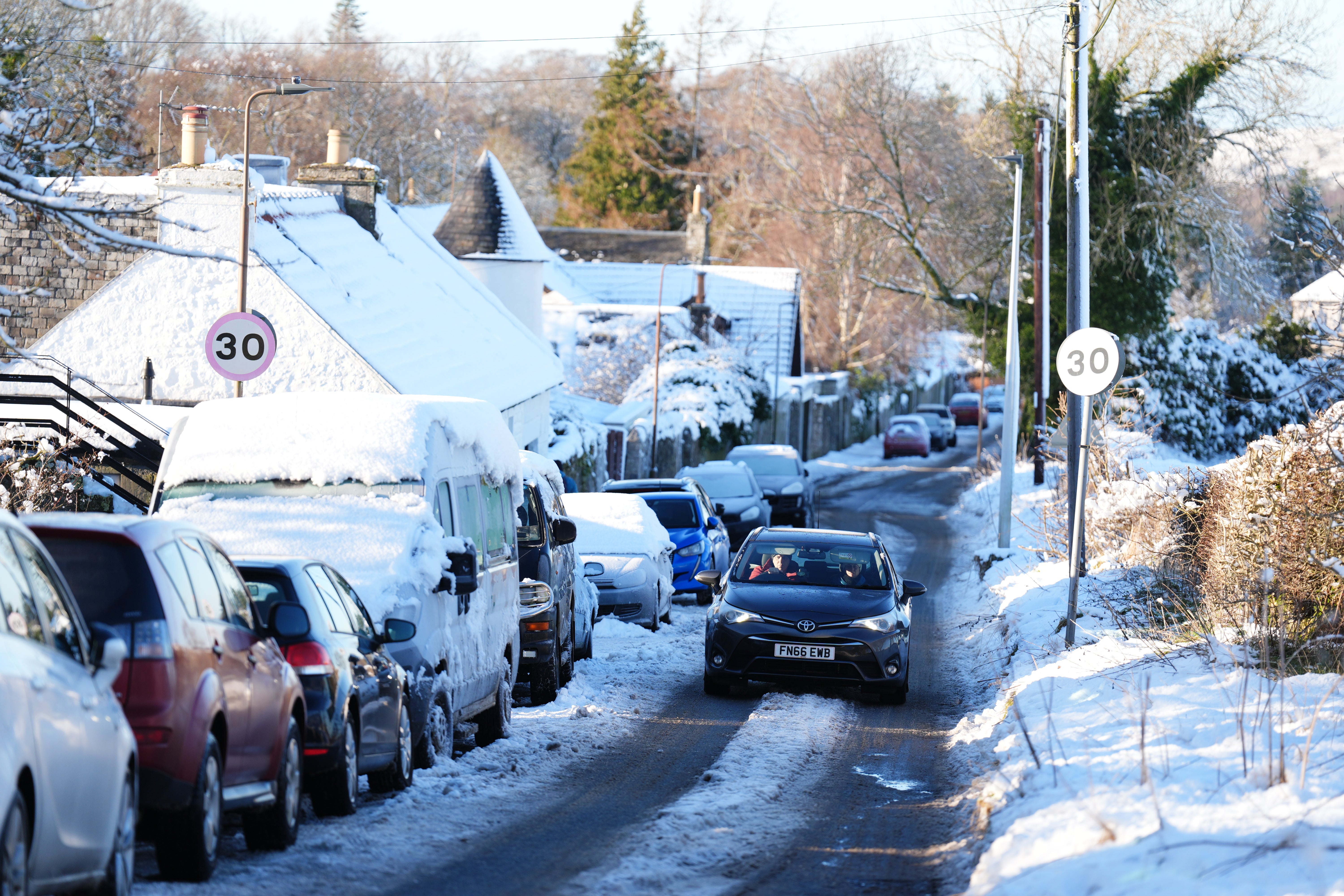 A car drives through snow in Balerno, Edinburgh amid freezing conditions across the UK