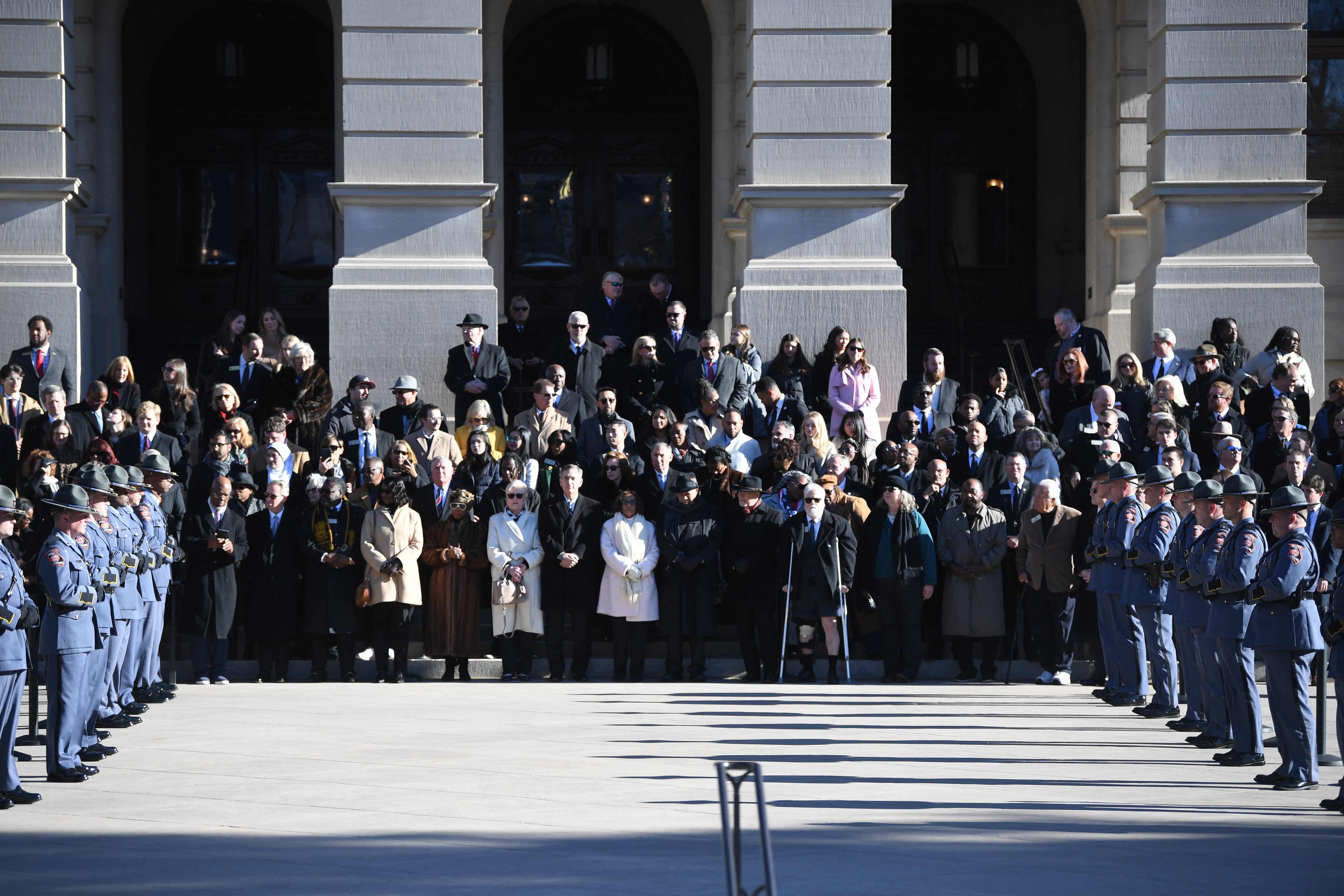 Mourners and Carter’s family members watch as his casket arrives at the State Capitol