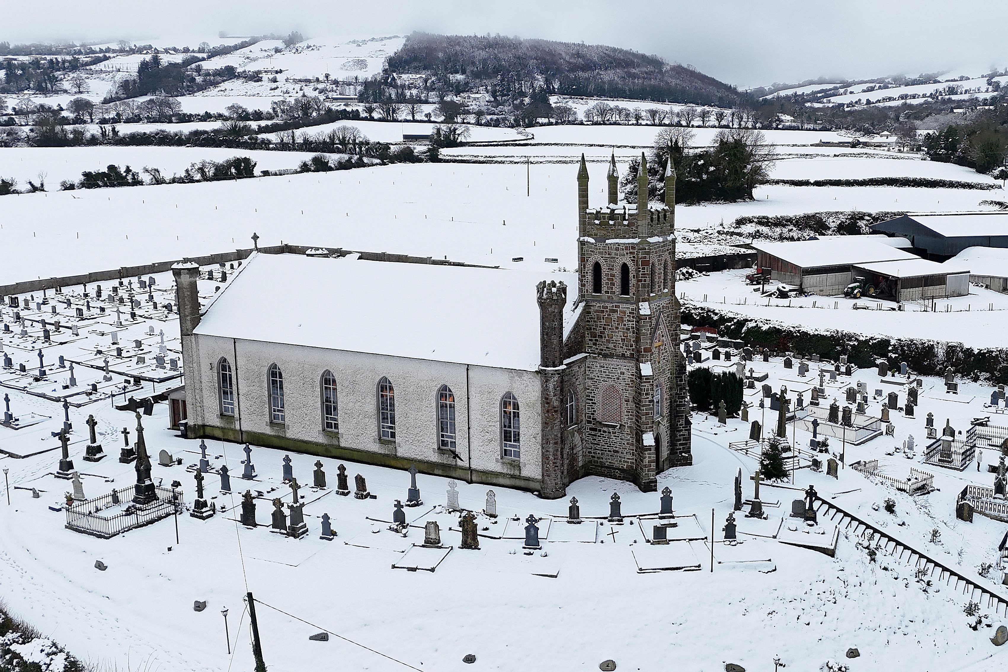 People make their way through snow to Mass at Holy Cross Catholic Church in Killeshin, Co Laois (Niall Carson/PA)