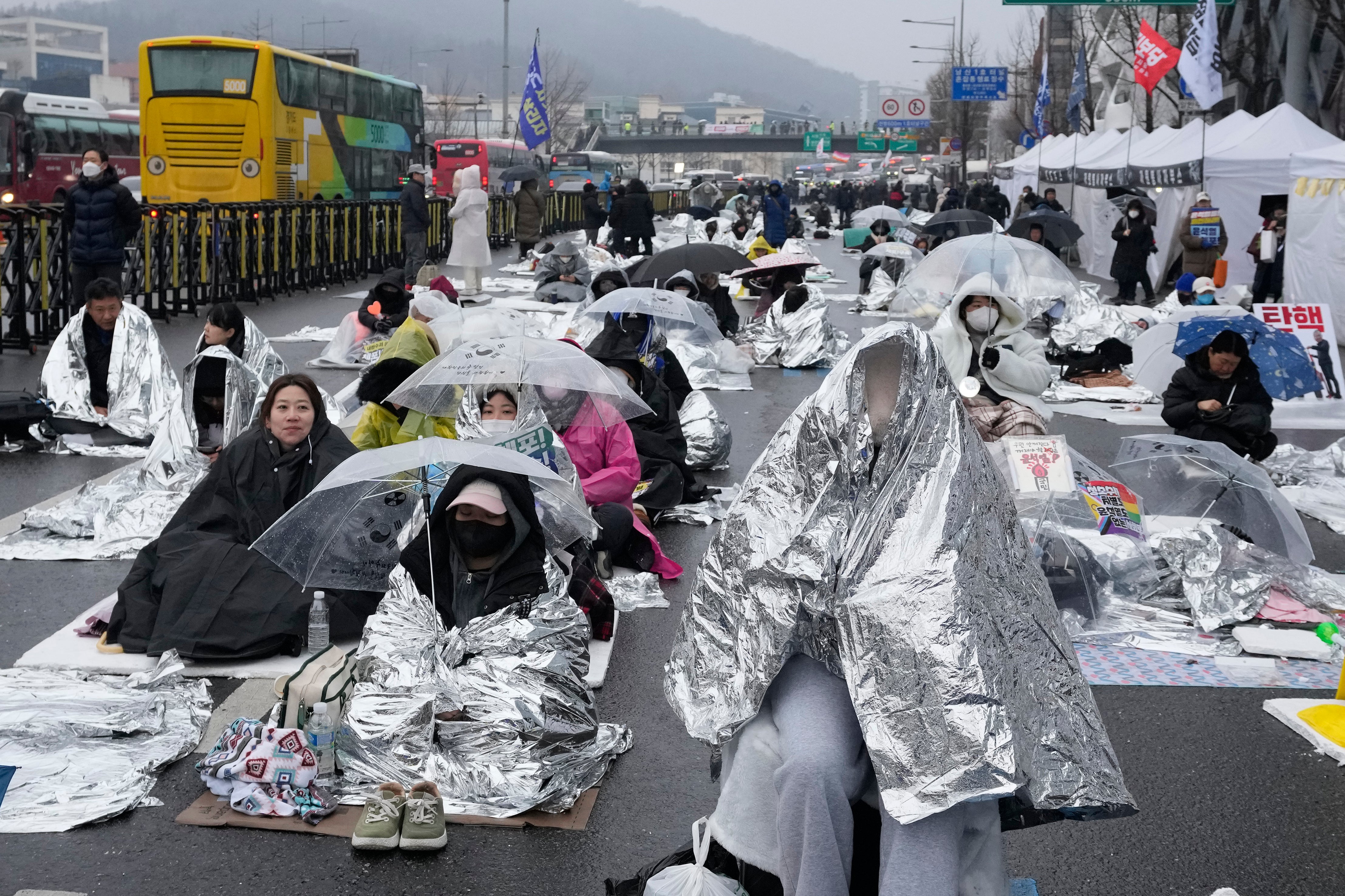 Protesters wait for a rally demanding the arrest of impeached South Korean president Yoon Suk Yeol in Seoul on 6 January 2025