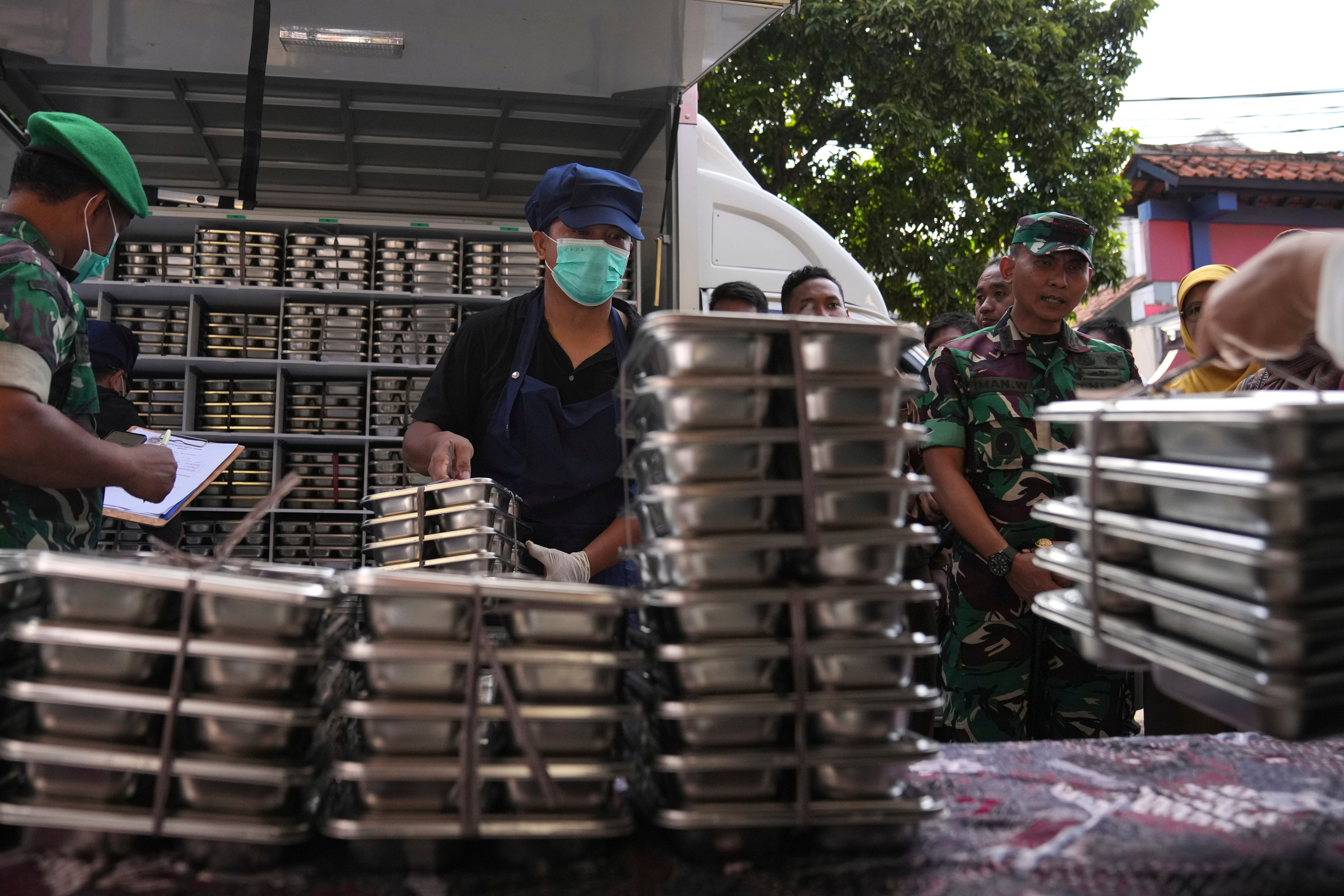 Workers unload meals to be distributed through the free programme