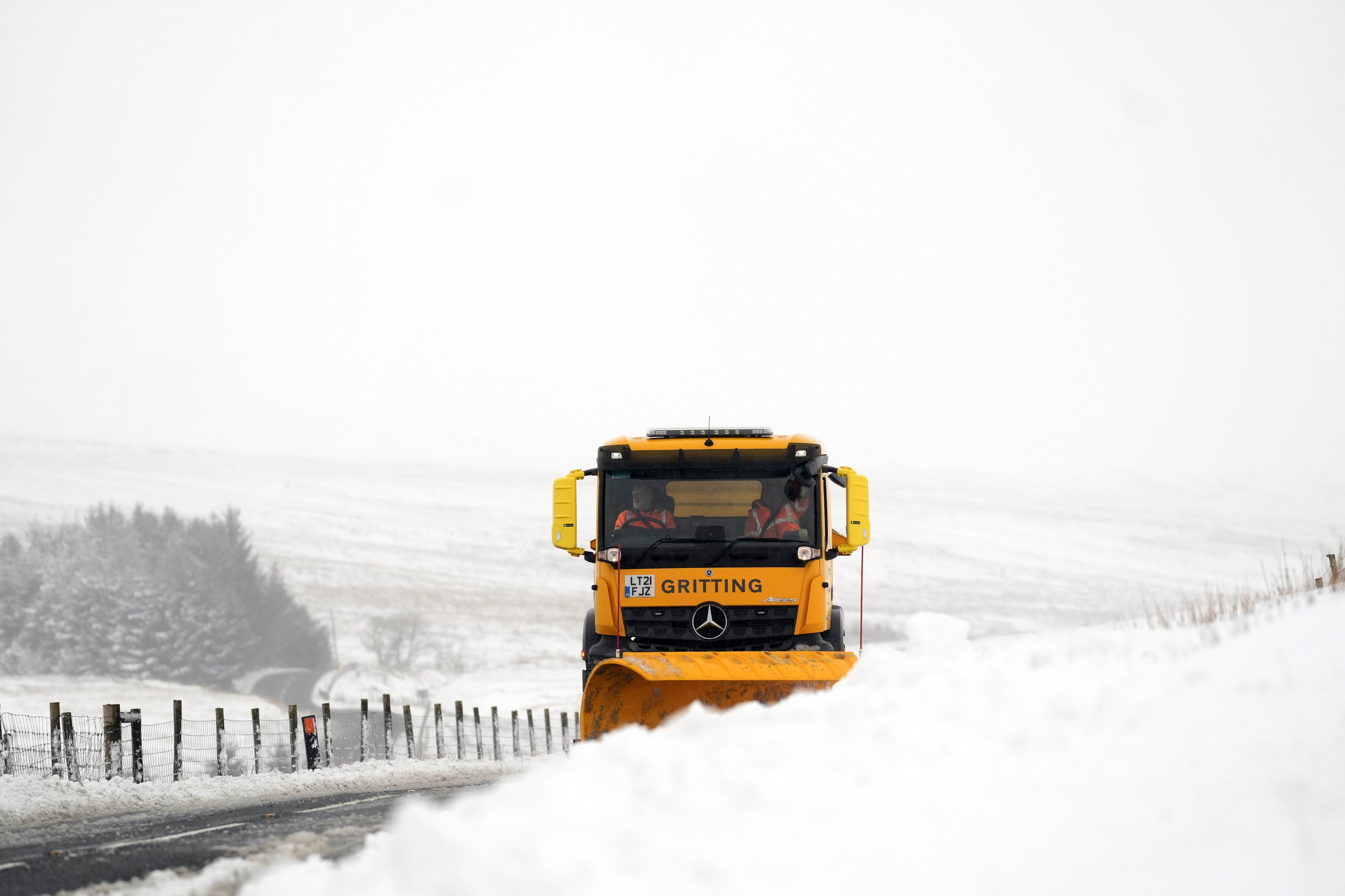 A snow plough and gritting lorry clears snow at Ribblehead, in North Yorkshire (Danny Lawson/PA)