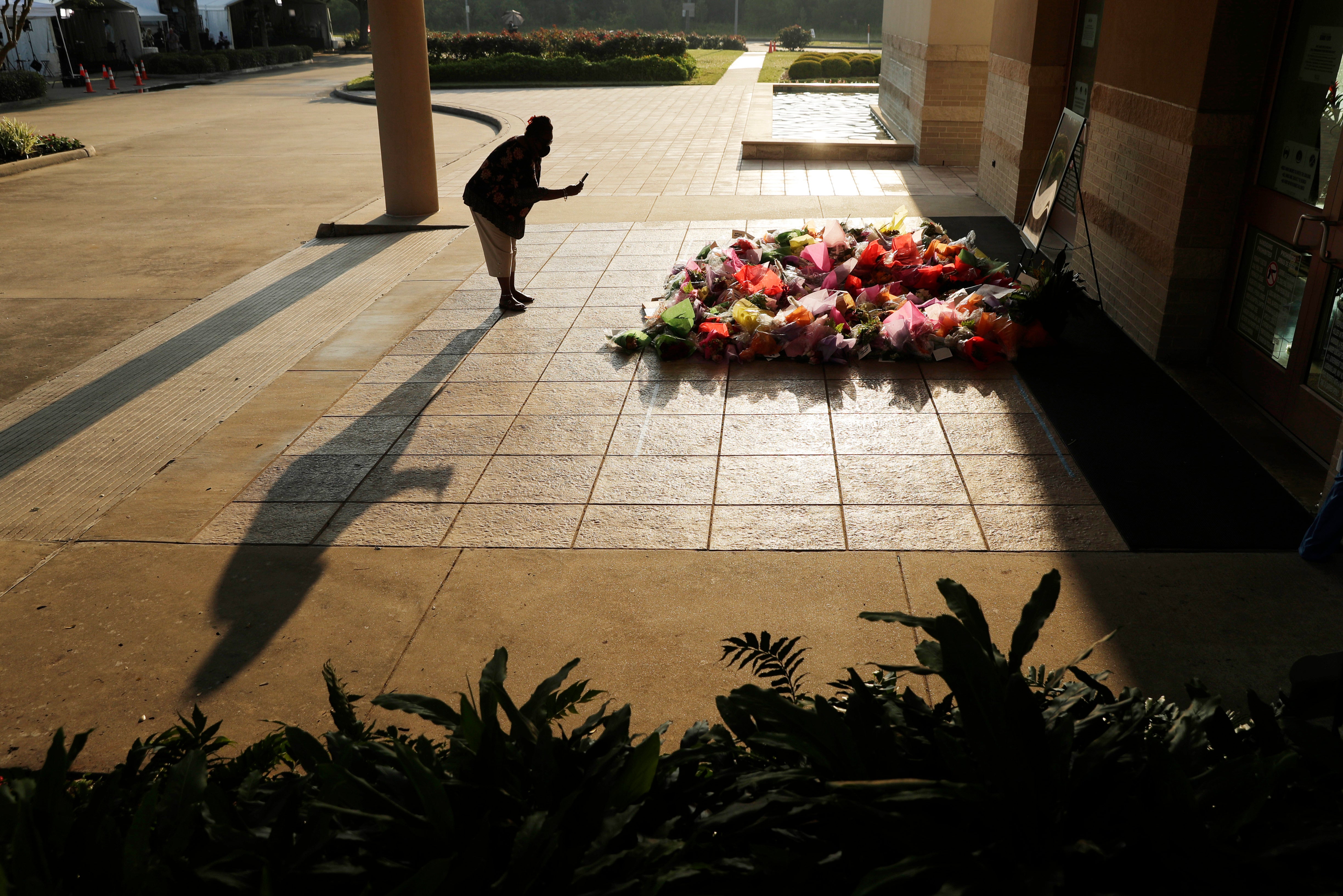 A woman stops to photograph a memorial for George Floyd at The Fountain of Praise church in Houston, June 9, 2020, in Houston. (AP Photo/Eric Gay, File)
