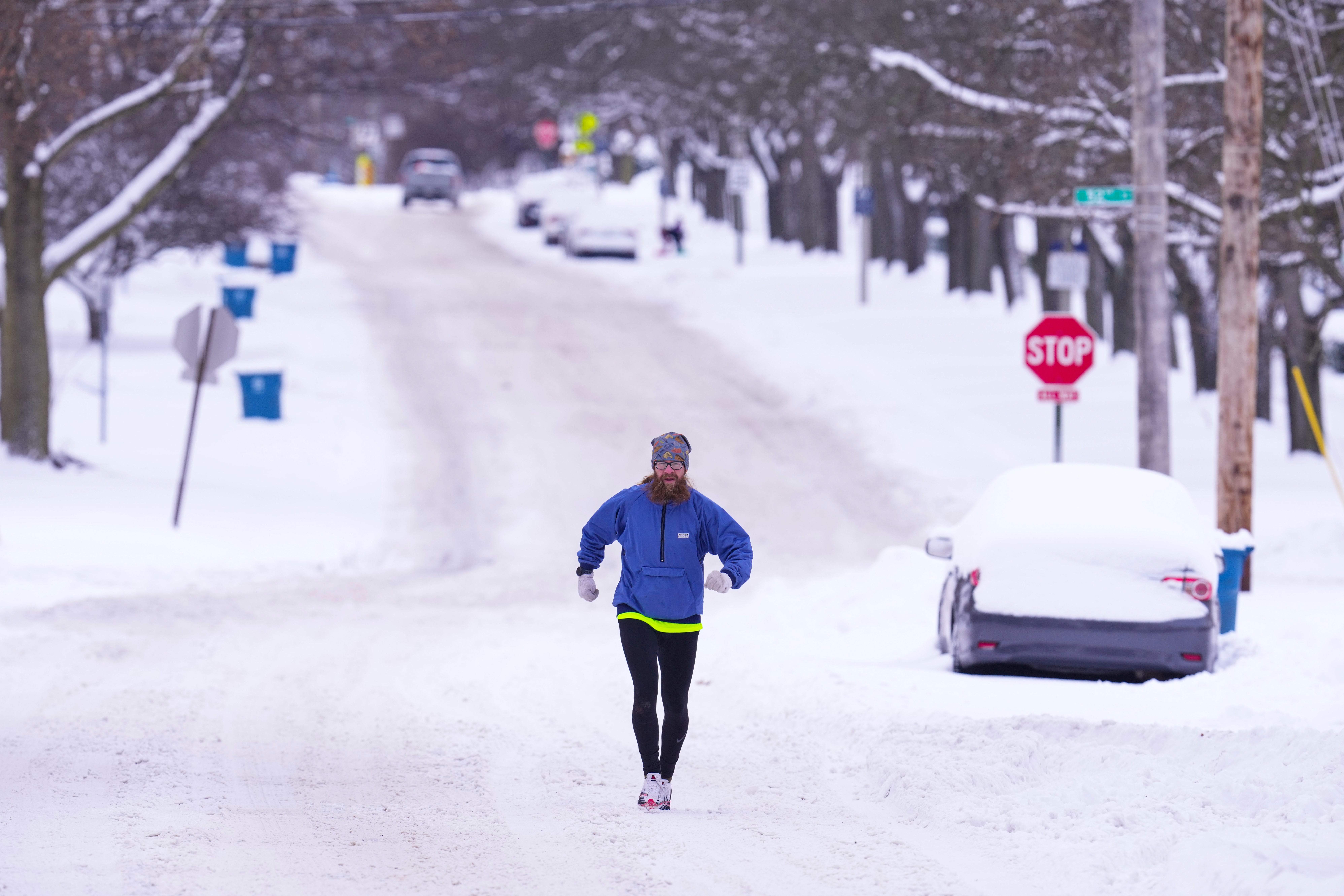 A runner makes his way through a snow-covered street in Indianapolis, Indiana, on Monday. A deadly winter storm was impacting a large swath of the eastern U.S., making travel dangerously tricky