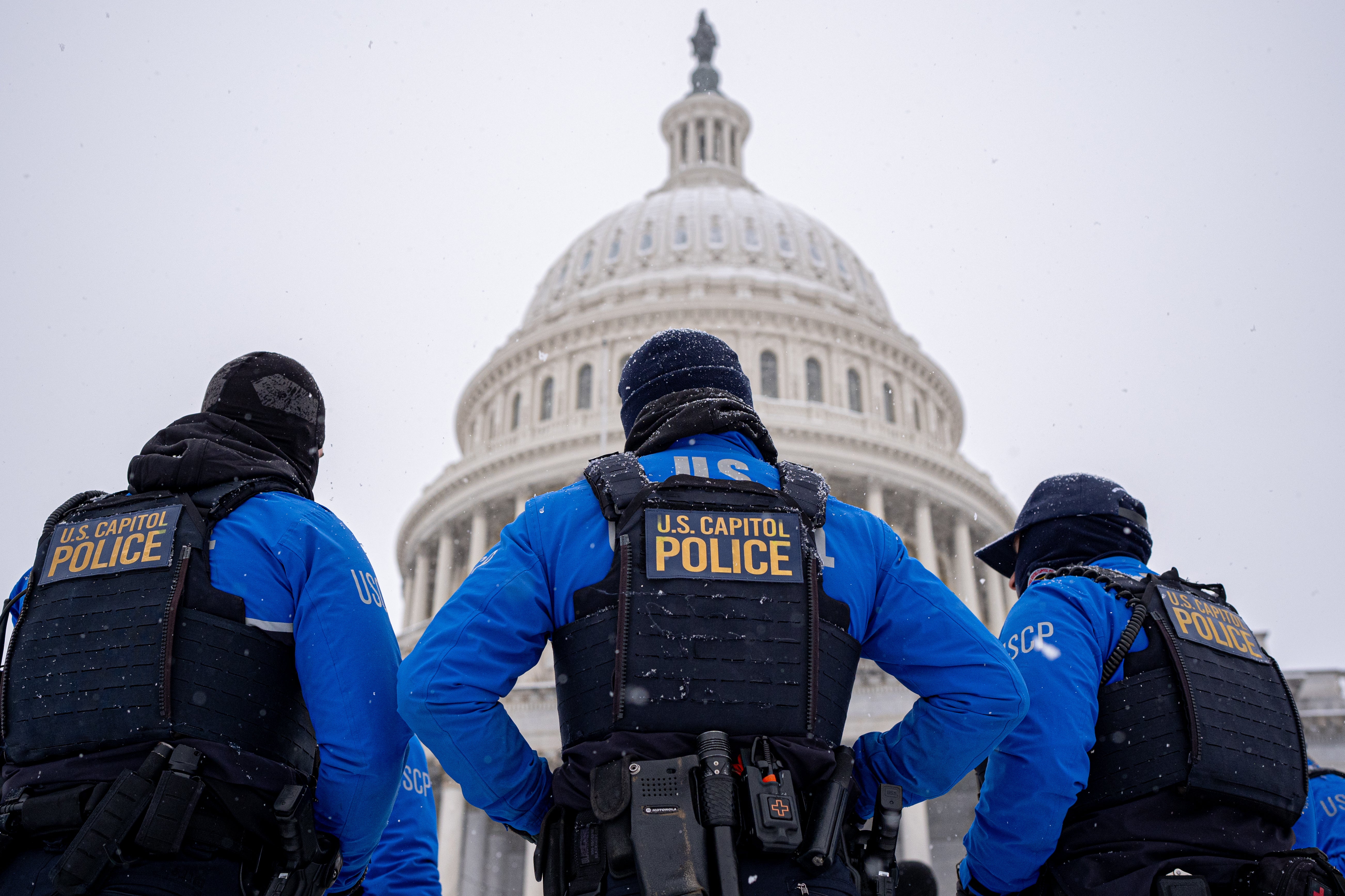 Three police officers stand in front of the U.S. Capitol Building on Monday in Washington, D.C. ,Monday marks the fourth anniversary since rioters stormed the Capitol