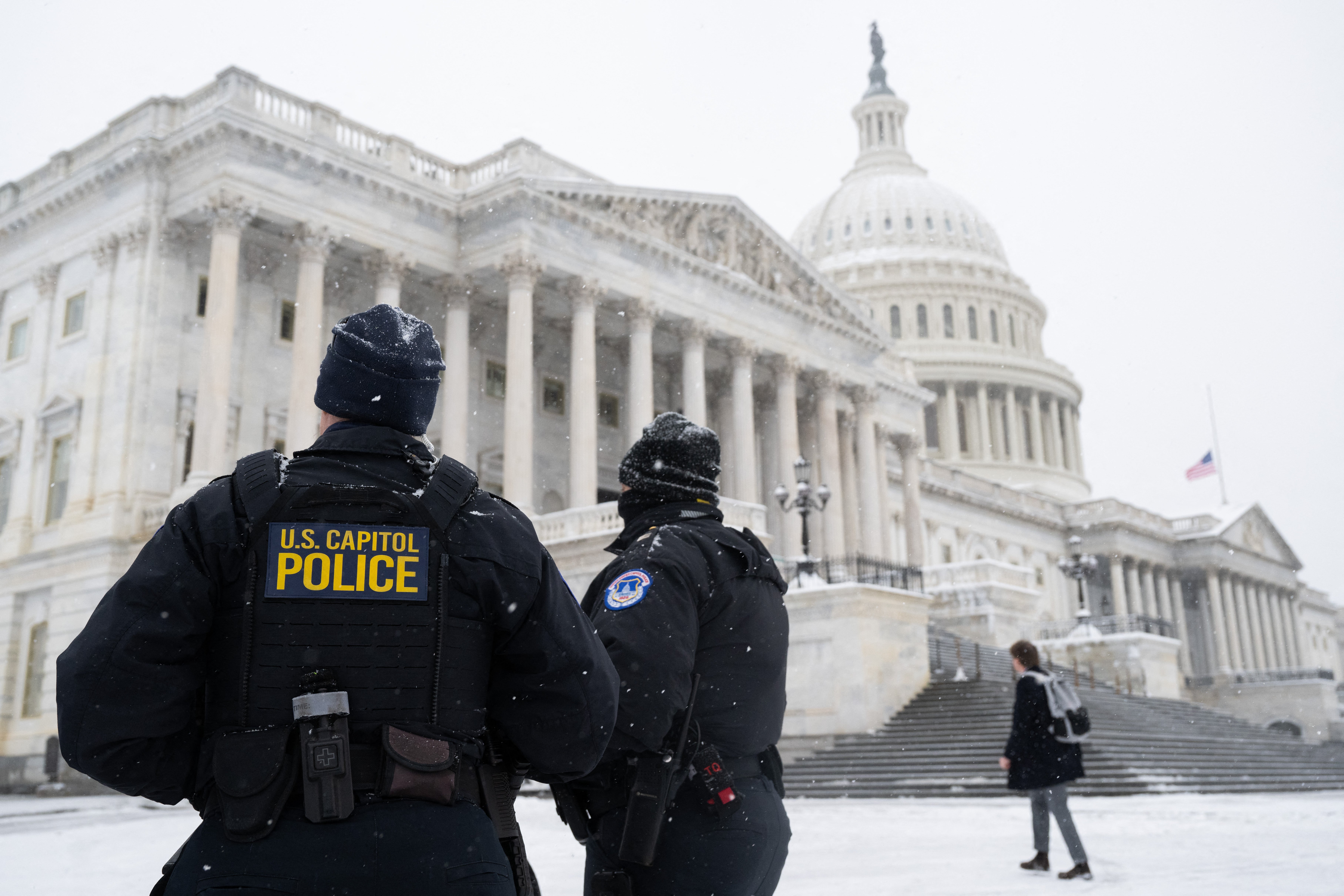 U.S. Capitol Police officers stand watch outside the U.S. Capitol building as snow falls ahead of a joint session of Congress. Travel in the area has been snarled by Winter Storm Blair