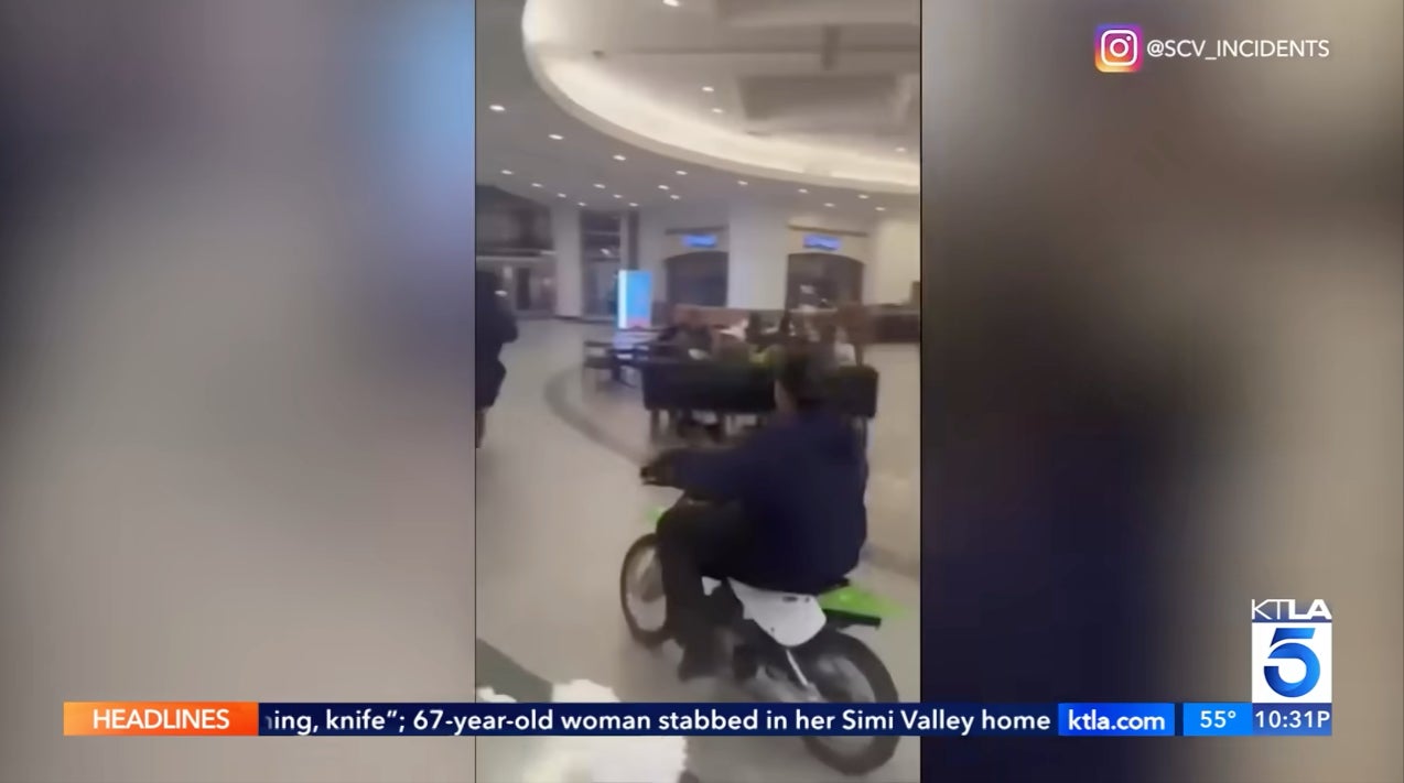 The dirt bike riders drove dangerously close to a group of children eating inside the food court