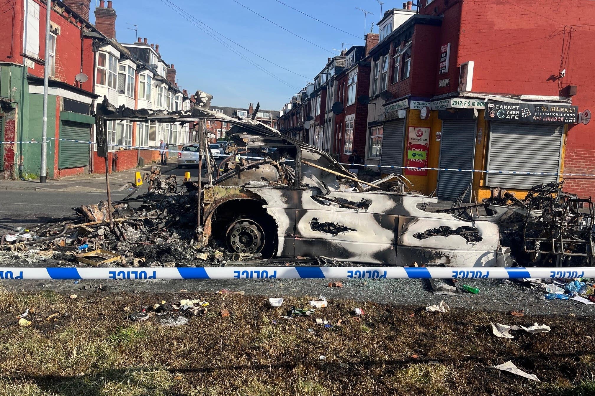 A burnt out vehicle in the Leeds suburb of Harehills (Katie Dickinson/PA)