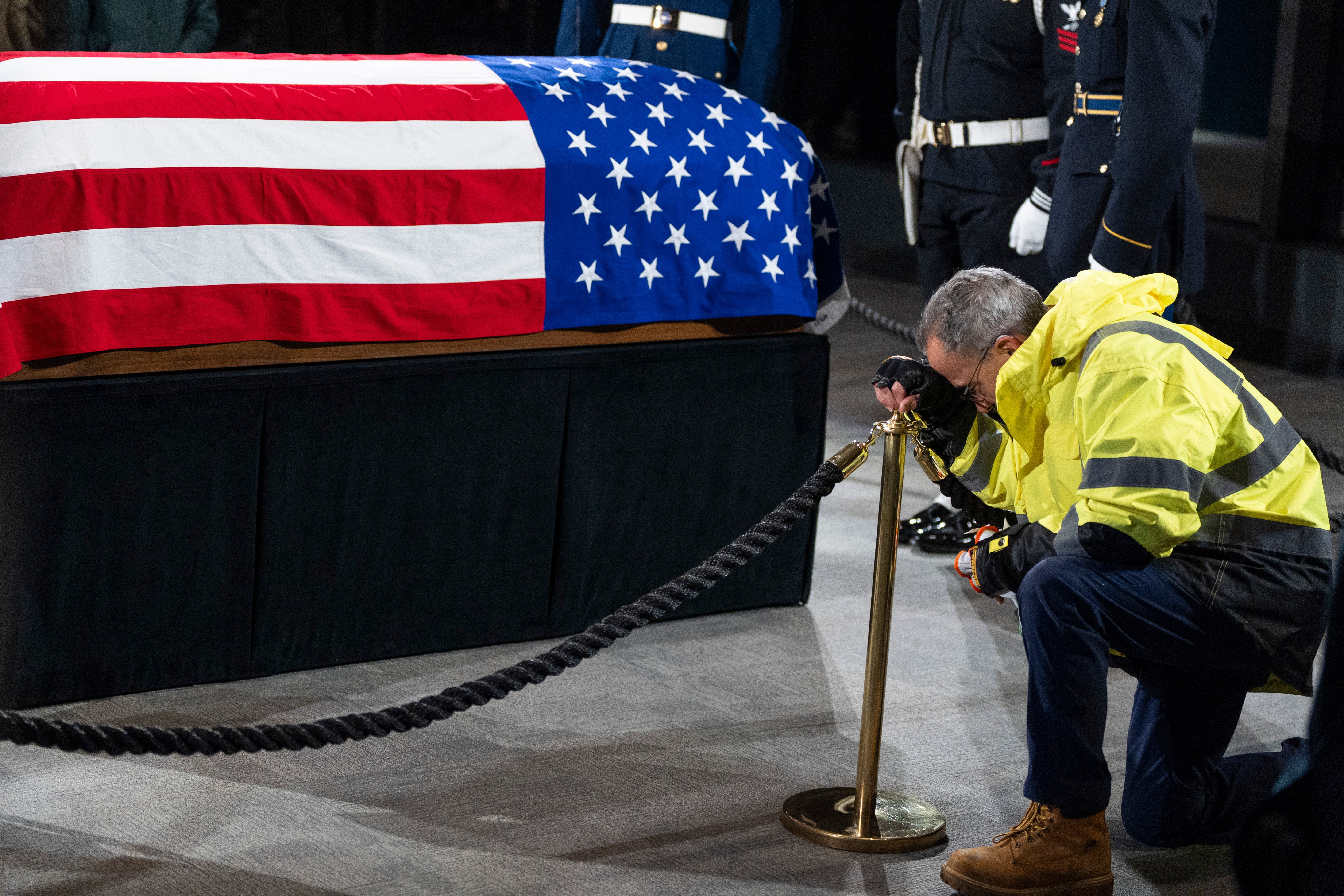 A mourner kneels at the casket of former President Jimmy Carter as he lies in repose at the Jimmy Carter Presidential Library and Museum on January 6, 2025 in Atlanta, Georgia