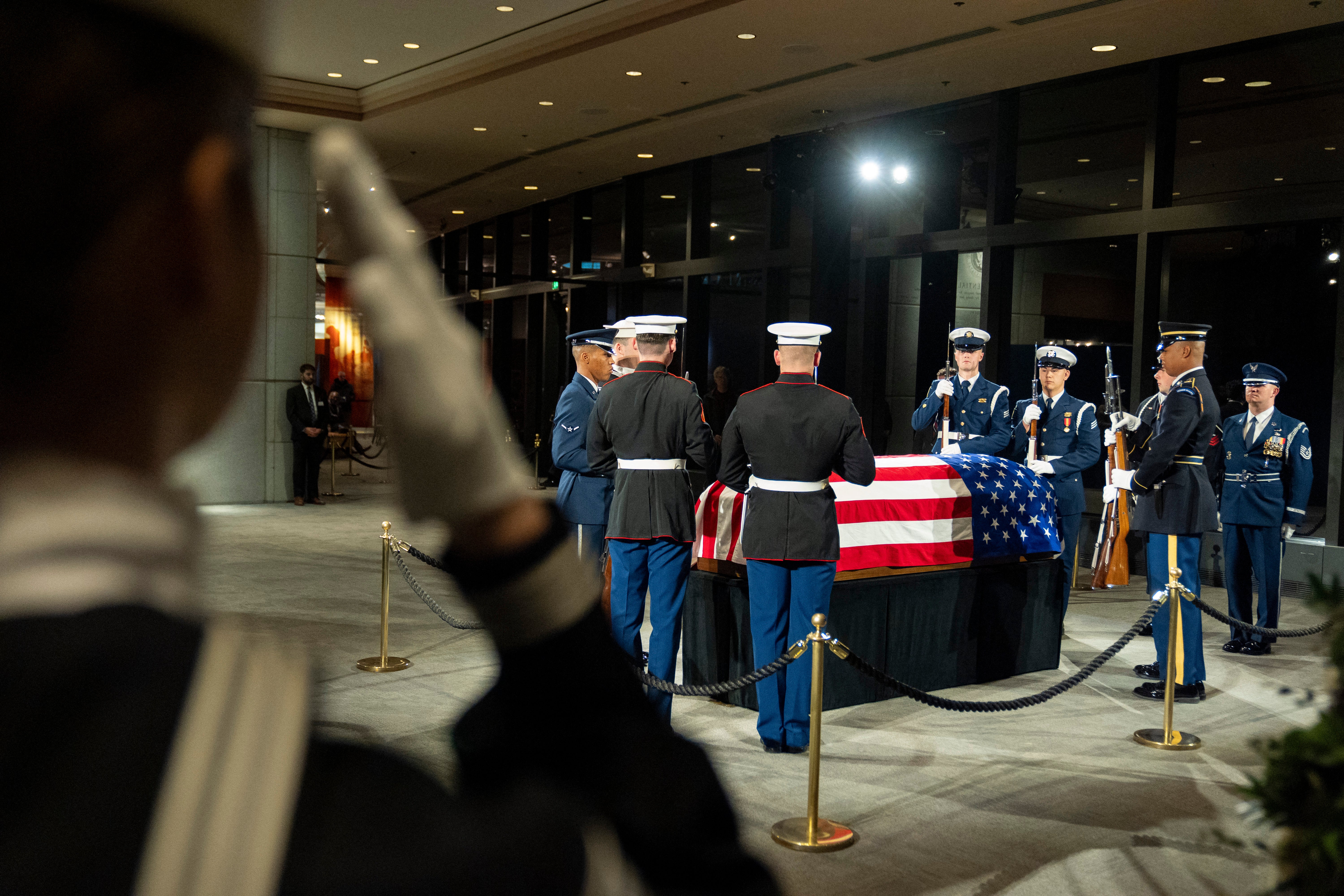 Members of the joint services military honor guard salute during the changing of the guard as the casket of former President Jimmy Carter lies in repose at the Jimmy Carter Presidential Library and Museum in Atlanta, Georgia on January 7, 2025