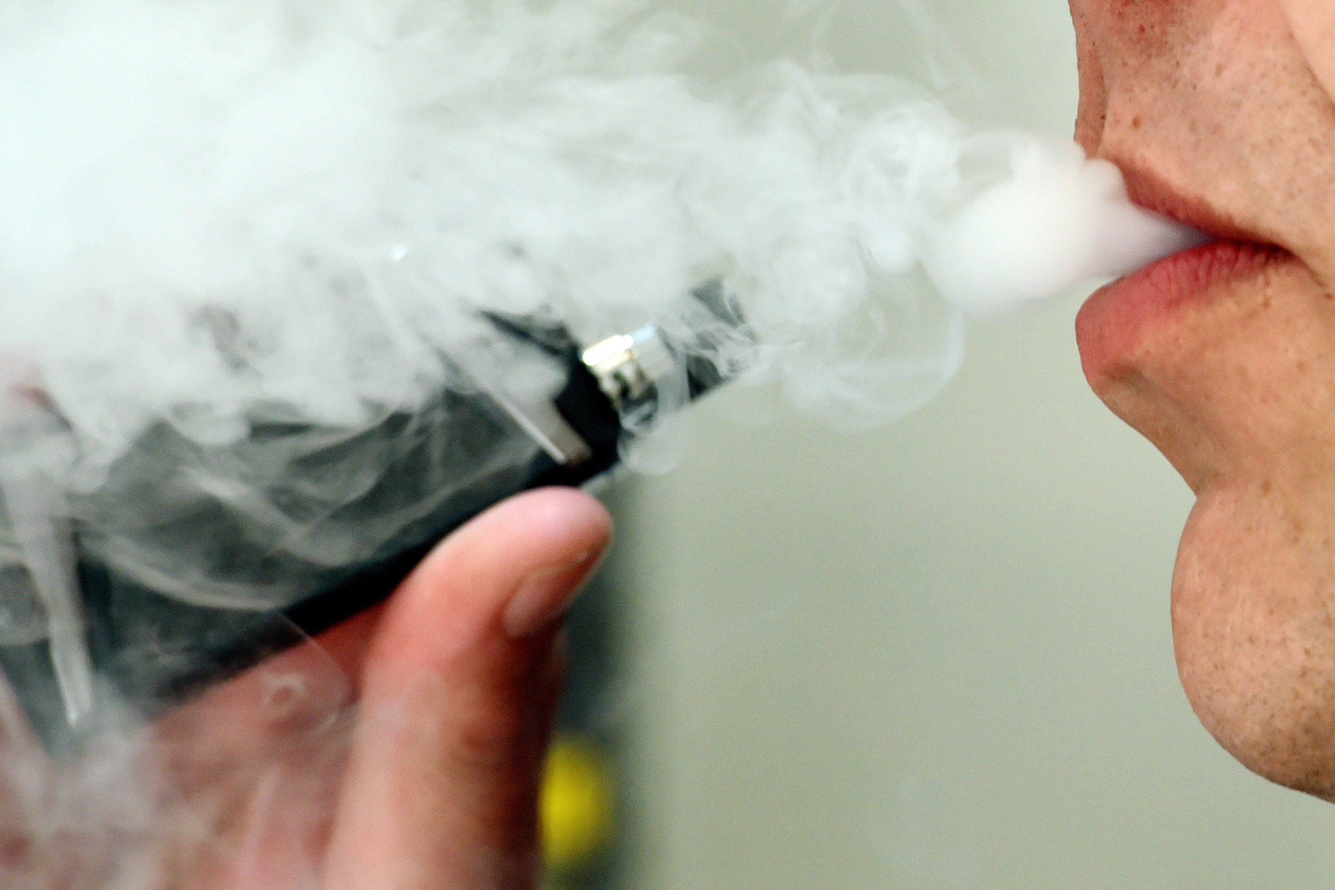 A man exhaling whilst using a vaping product (PA)