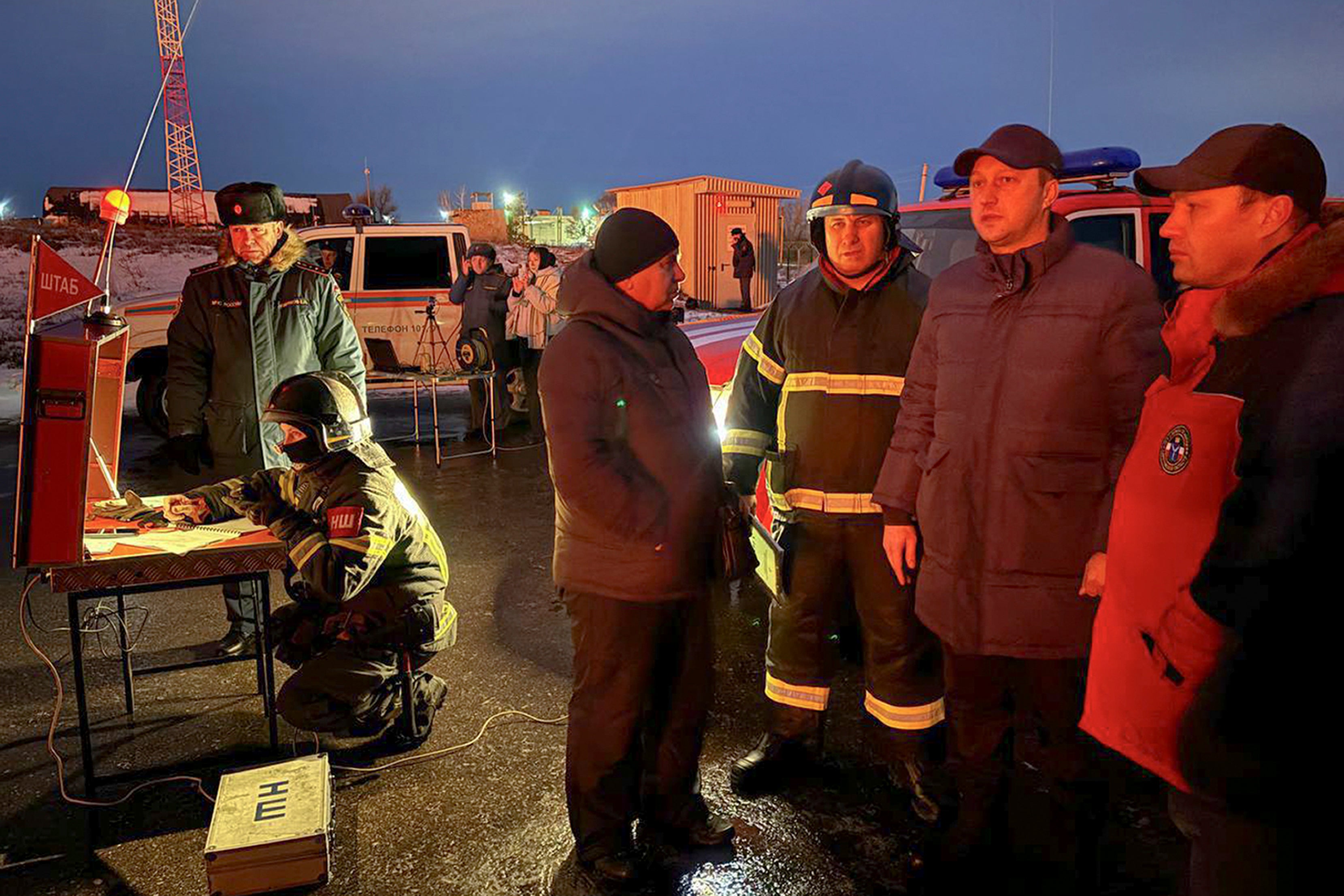 Governor of the Saratov region Roman Busargin, second right, speaks to firefighters and rescuers at the industrial side damaged after Ukrainian drones' attack in Saratov, Russia