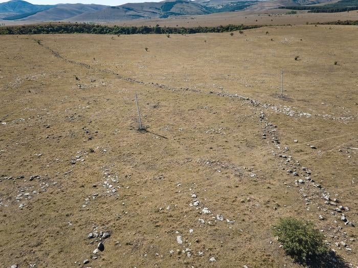 Photo of 1km long outer fortification wall with power line poles nearby for scale