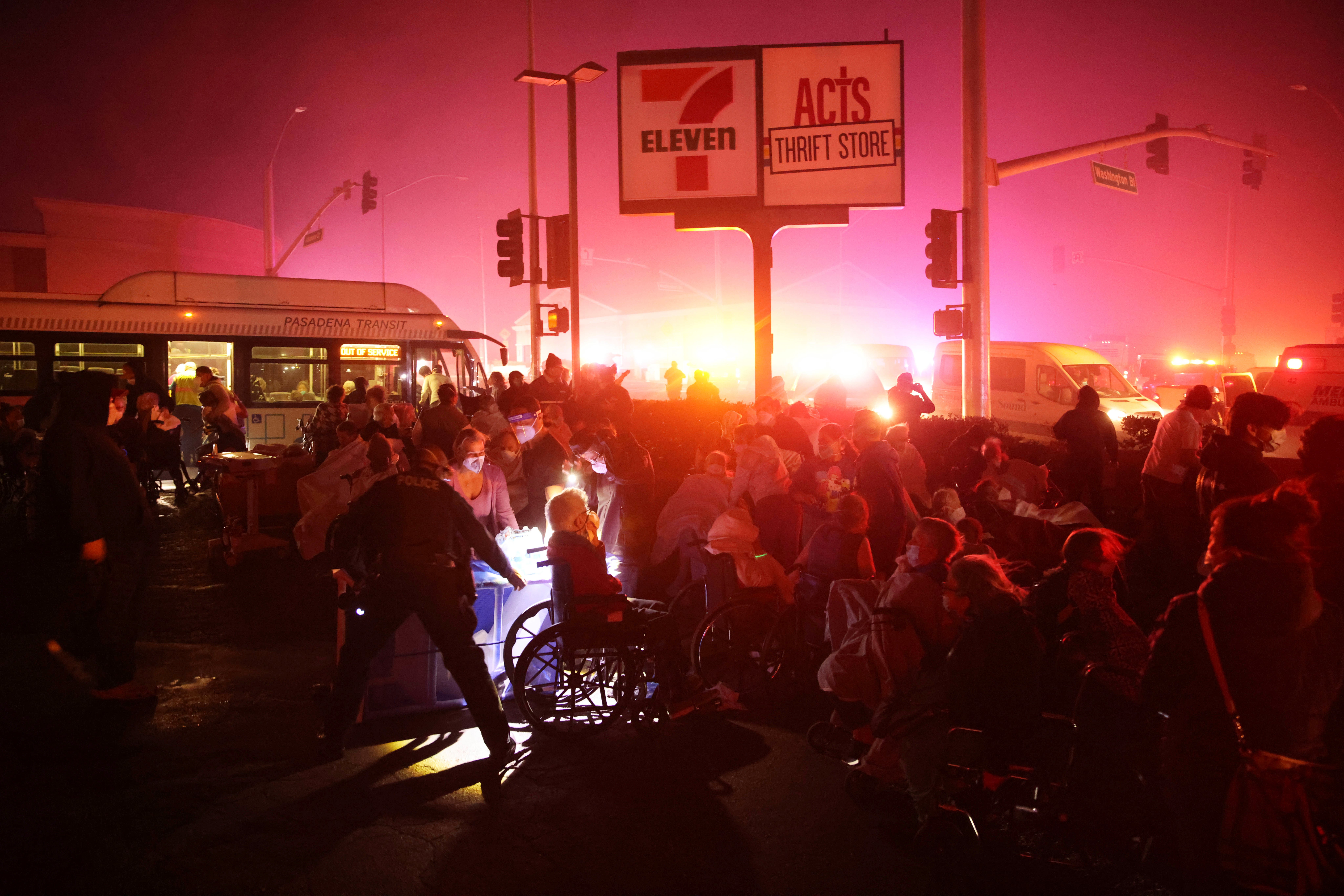 Residents of a senior center are evacuated as the Eaton Fire approaches Tuesday in Altadena. The flames, paired with the glow of emergency vehicles, have created a Mars red sky over the region, where an estimated 100,000 people are under evacuation orders. In Altadena alone, roughly 42,000 residents were forced to evacuate, according to the Washington Post.