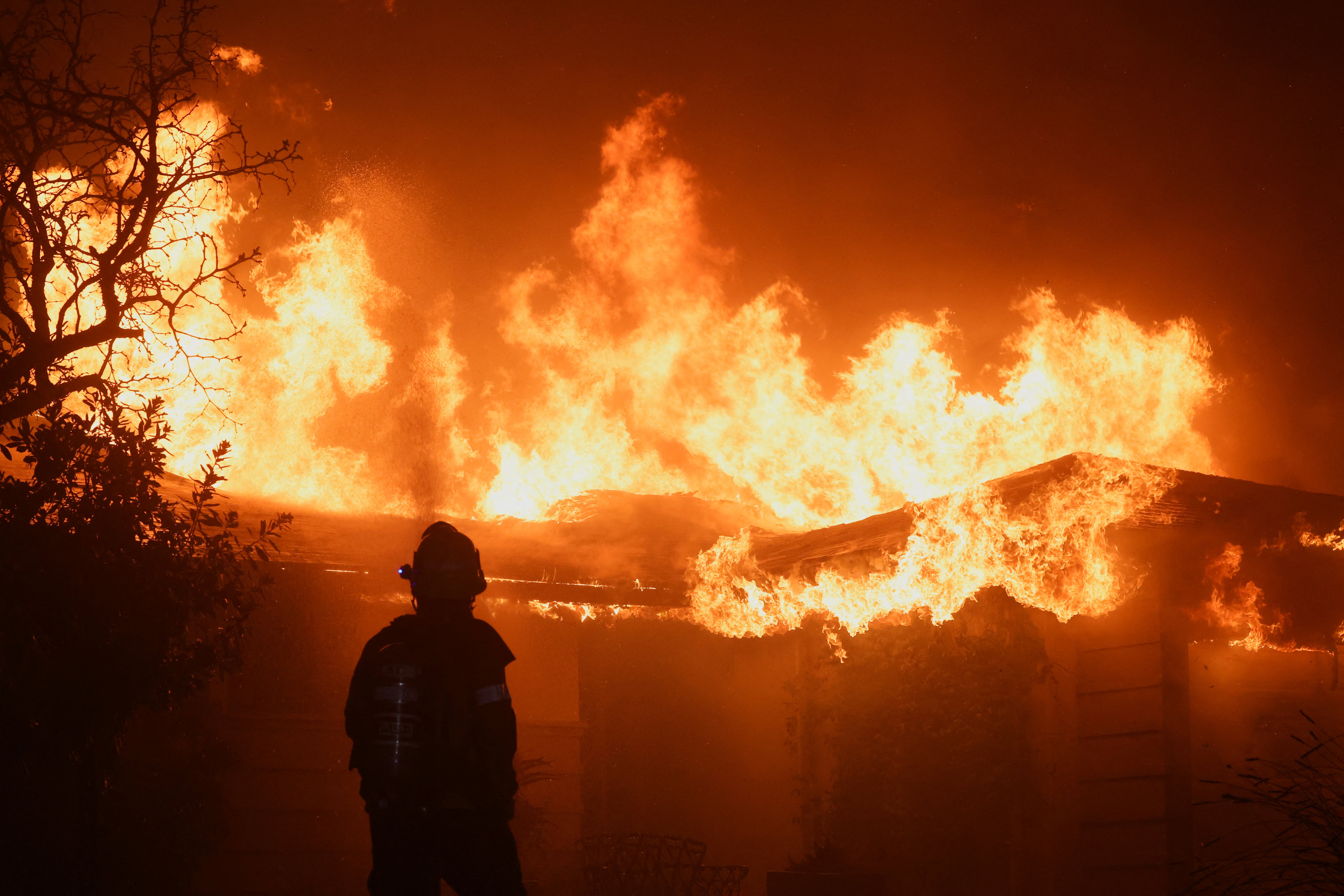 A firefighter works to extinguish flames as the Eaton Fire burns in Pasadena, California, on January 8