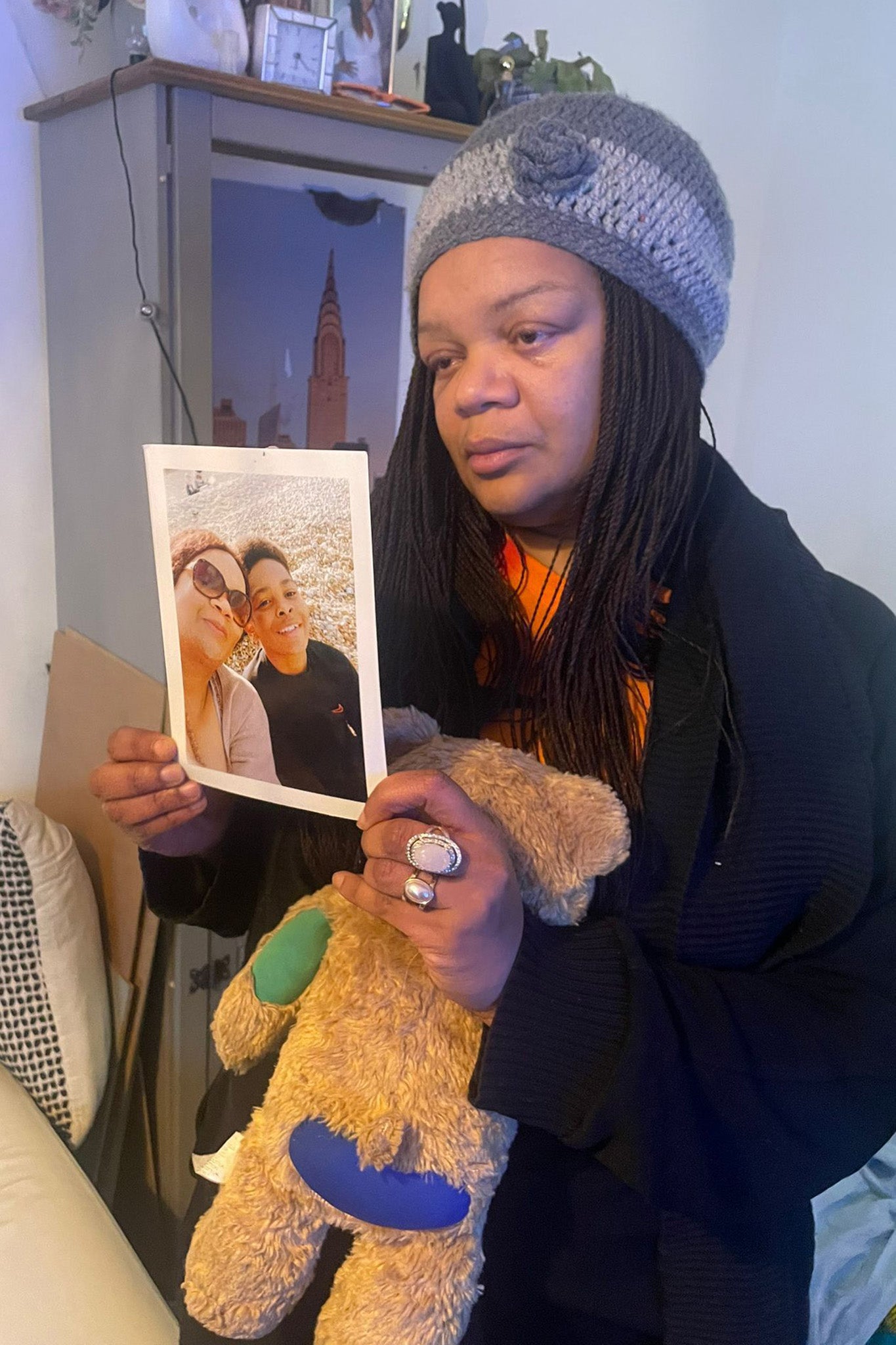 Kelyan’s mother holds a photo of her son and a teddy bear