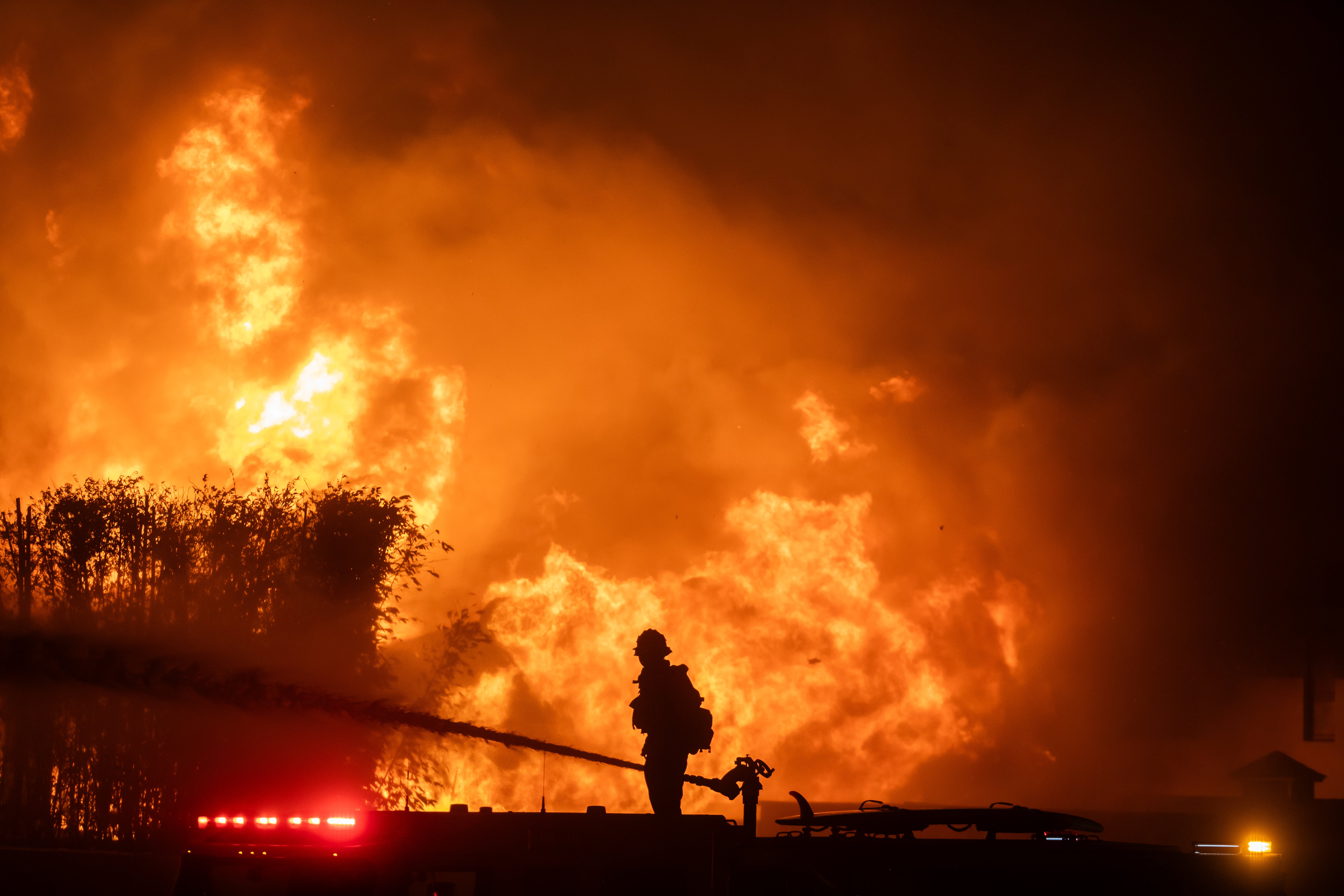 A firefighter stands on top of a fire truck to battle the Palisades Fire in Los Angeles, California, on Wednesday.