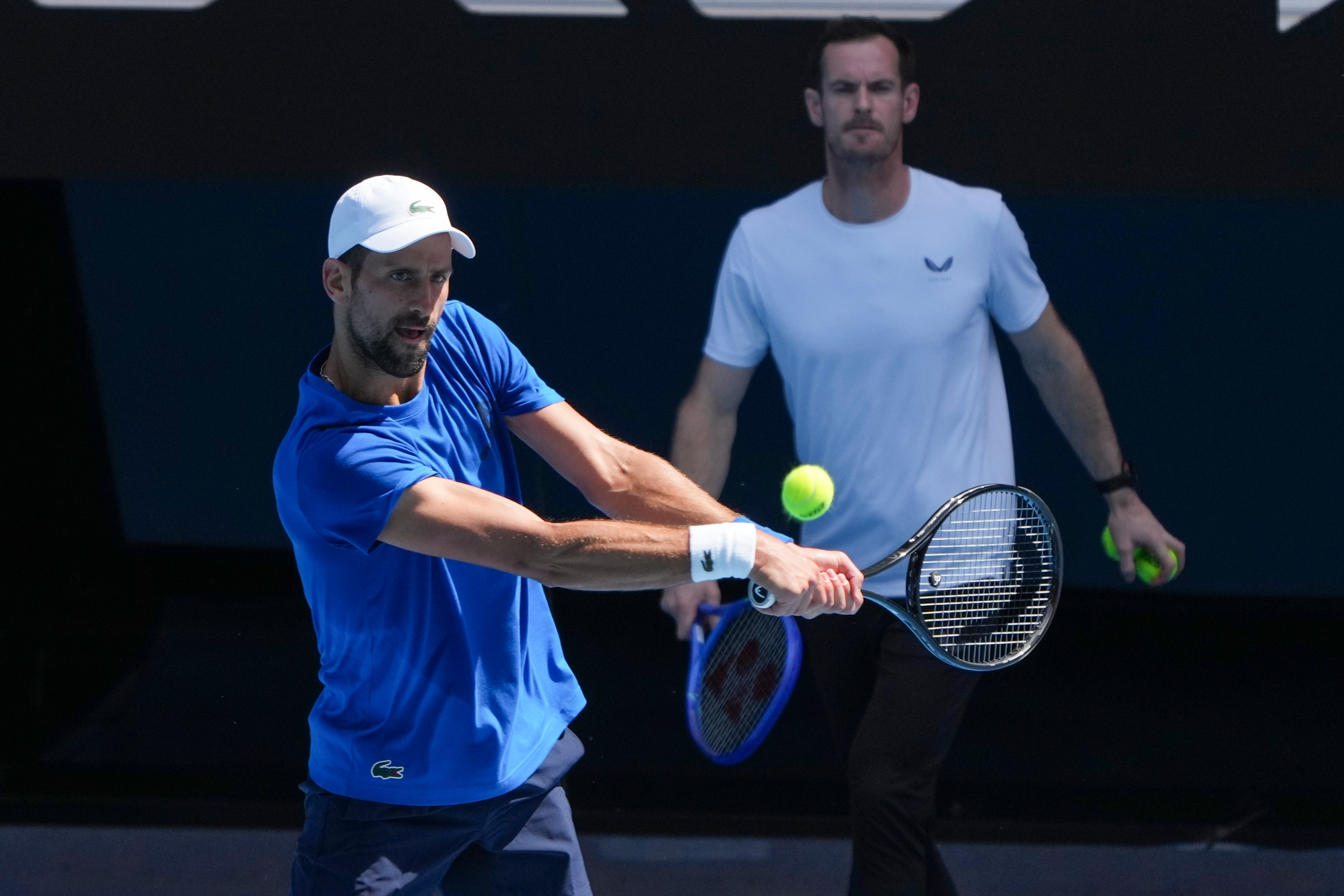 Andy Murray, right, watches Novak Djokovic practice (Mark Baker/AP)