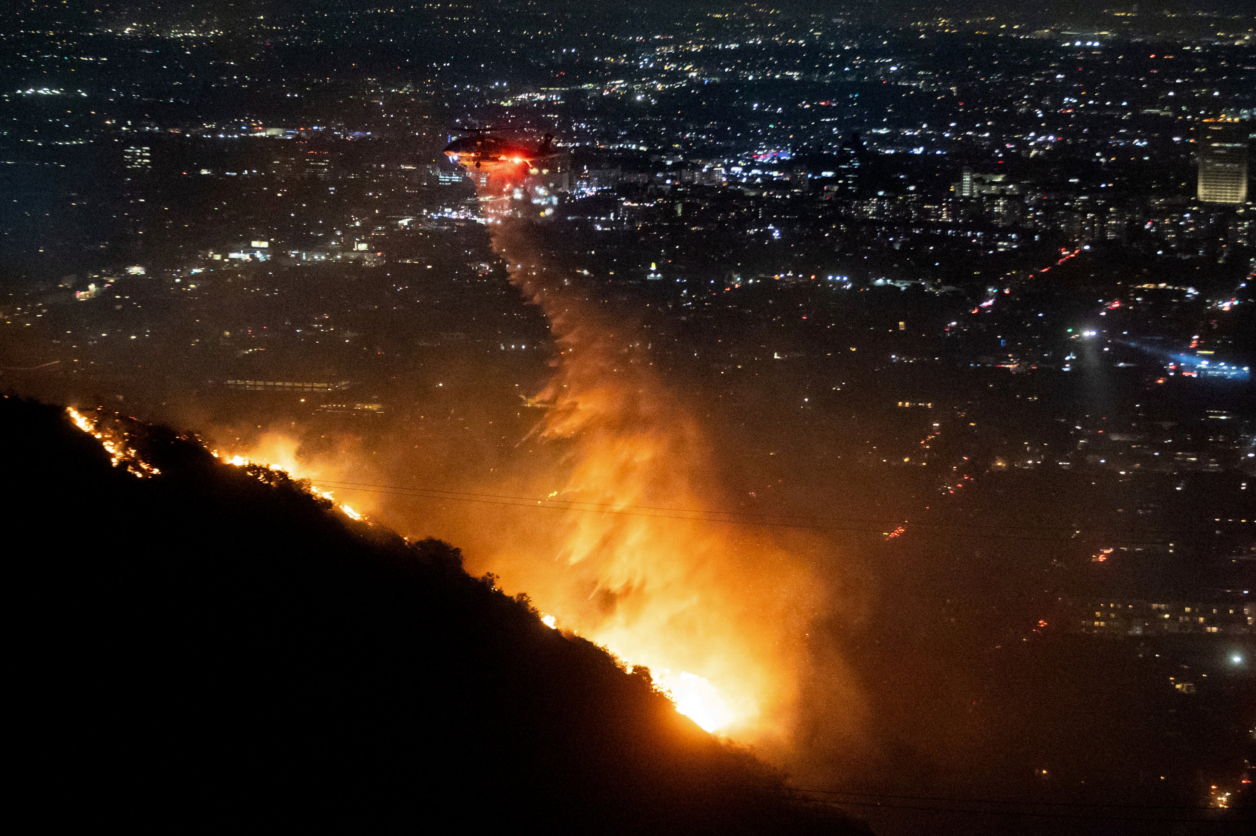 Water is dropped by helicopter on the burning Sunset Fire in the Hollywood Hills section of Los Angeles on Wednesday