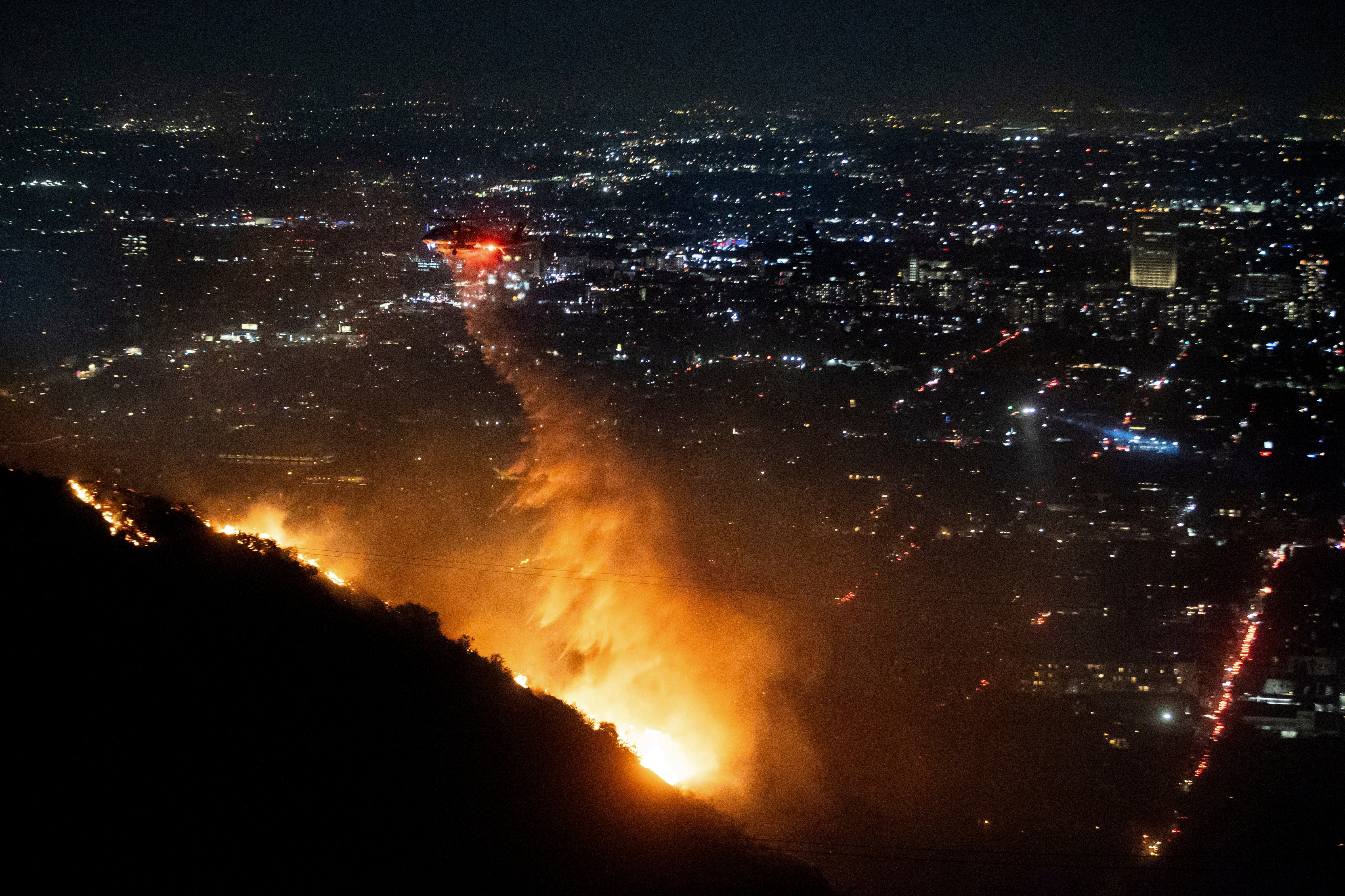 Water is dropped Wednesday by a helicopter on the burning Sunset Fire in the Hollywood Hills section of Los Angeles, California.