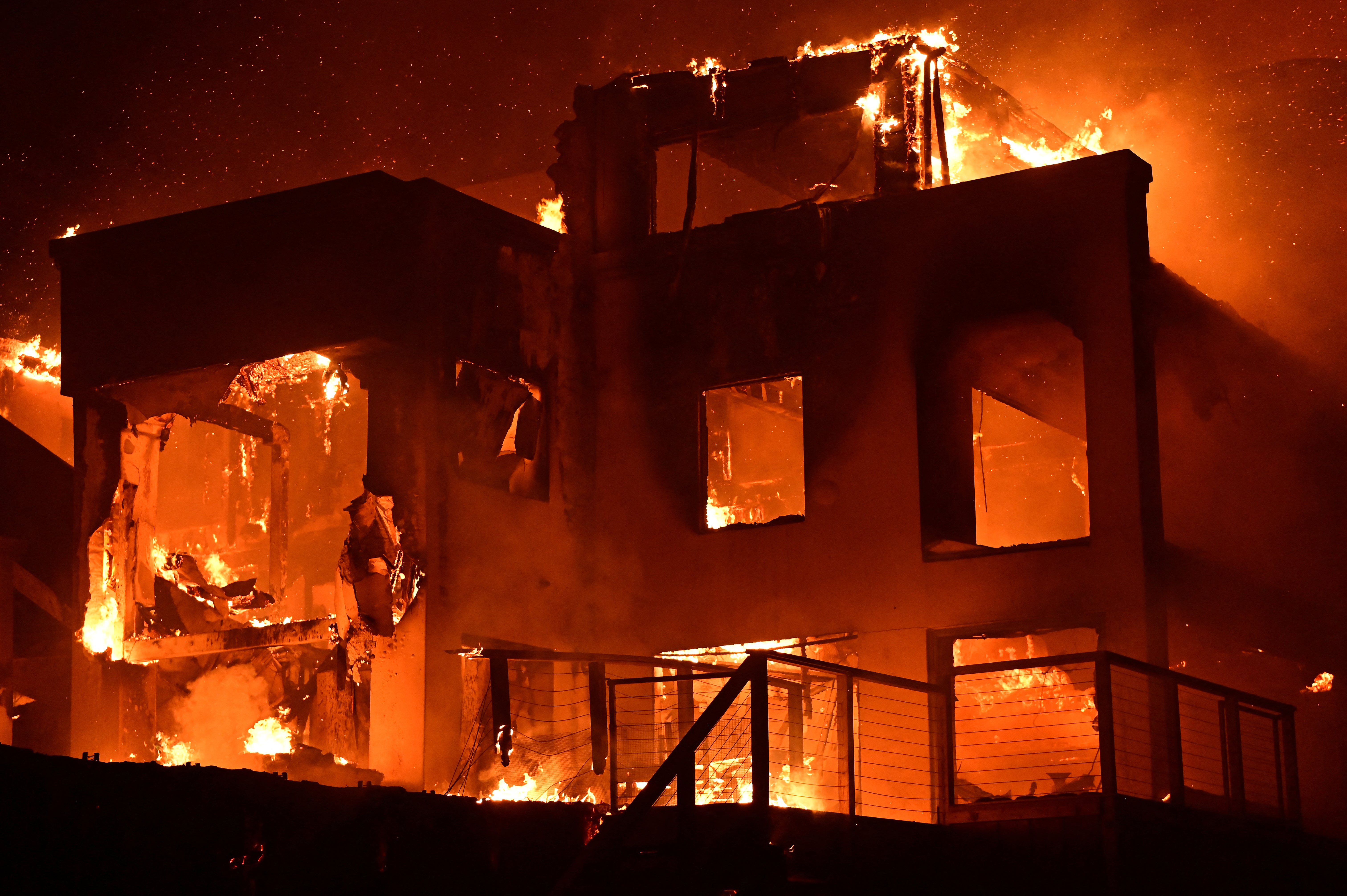 A house is engulfed in flames as the Palisades fire burns along Pacific Coast Highway in Malibu, California on Wednesday