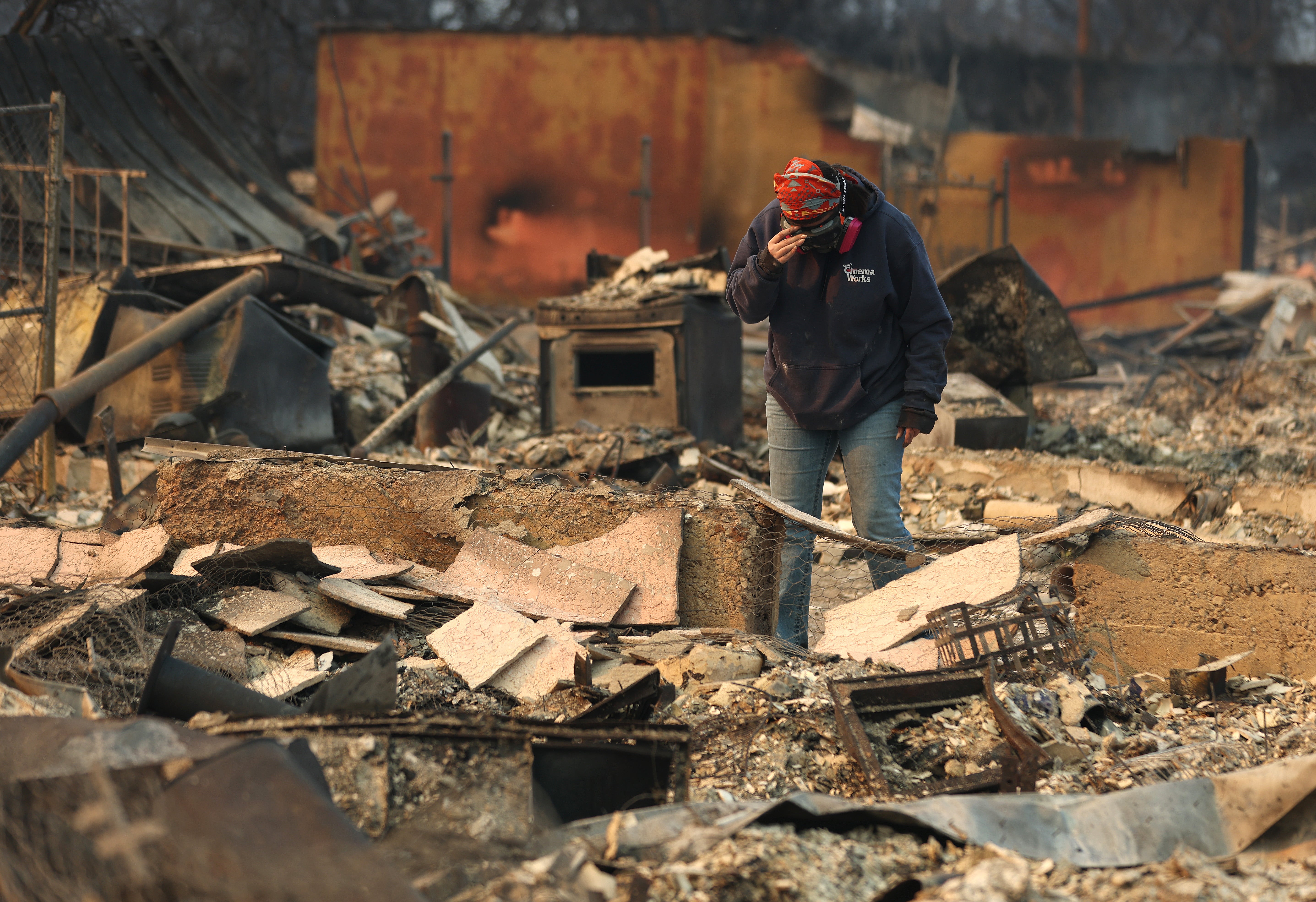 Mimi Laine pauses as she inspects her mother's home that was destroyed by the Eaton Fire on Thursday in Altadena, California.