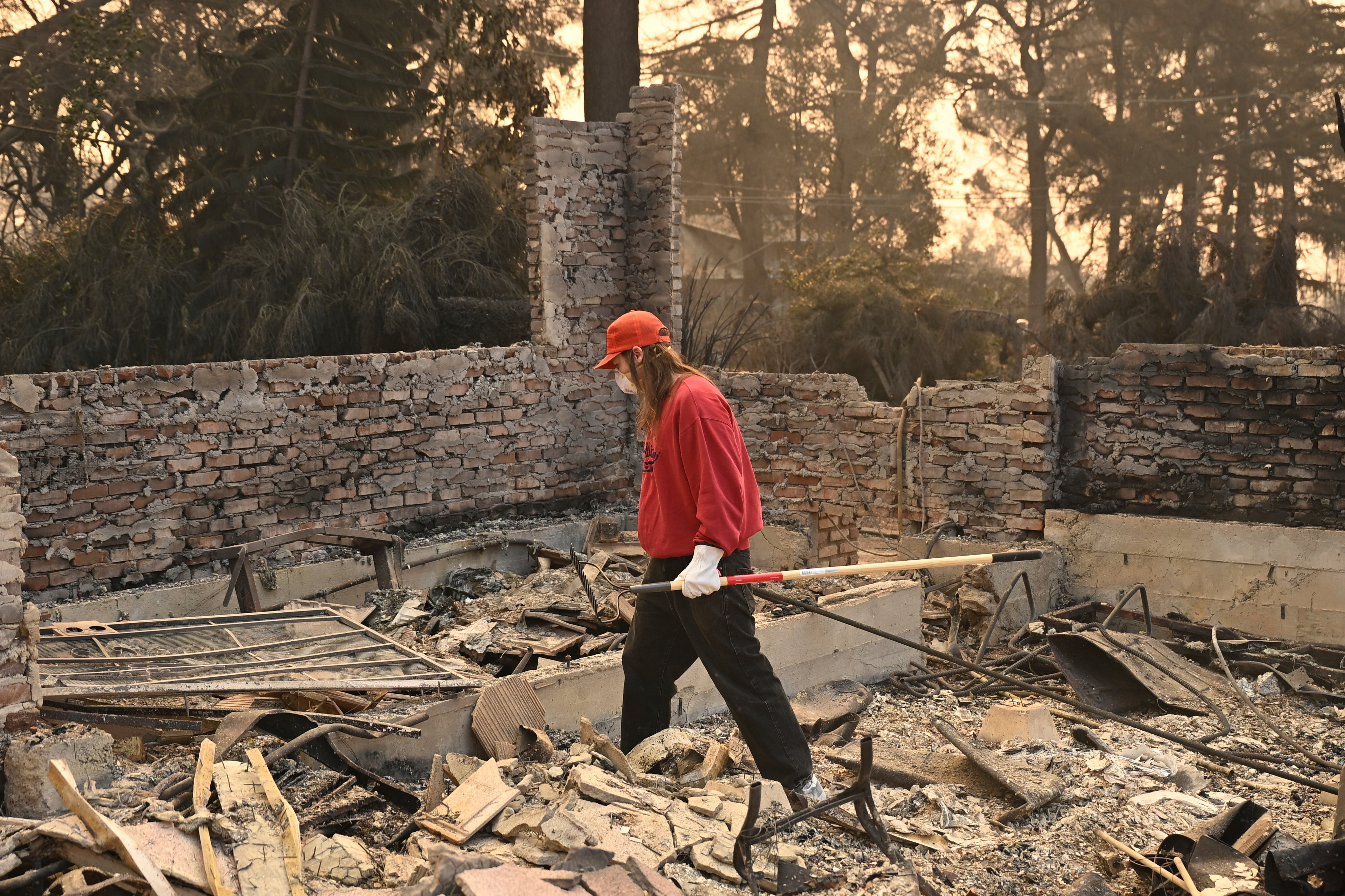 A man searches though his destroyed home after the Eaton Fire in Altadena