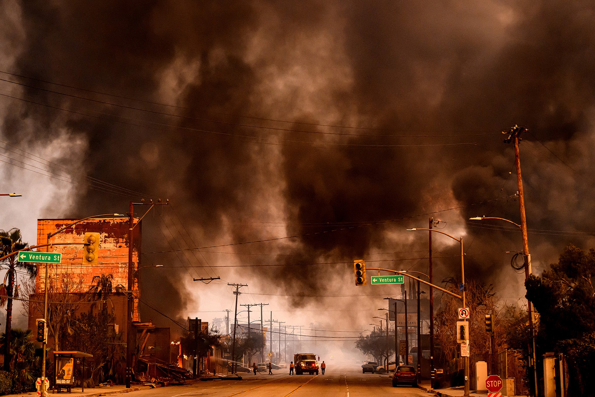 Smokes and flames overwhelms a commercial area during the Eaton fire in the Altadena area