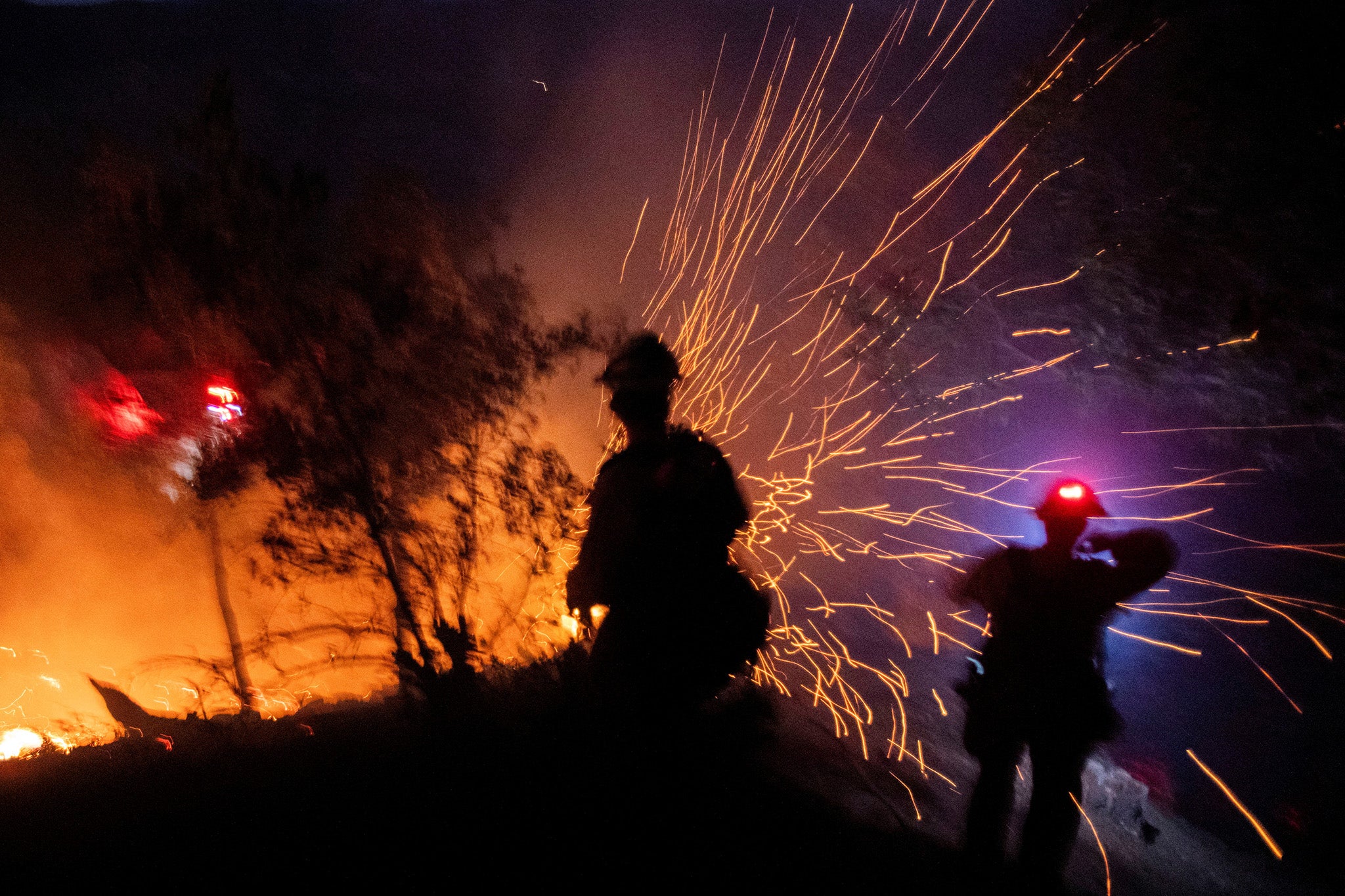 The wind whips embers while firefighters battle the fire in the Angeles National Forest near Mt. Wilson