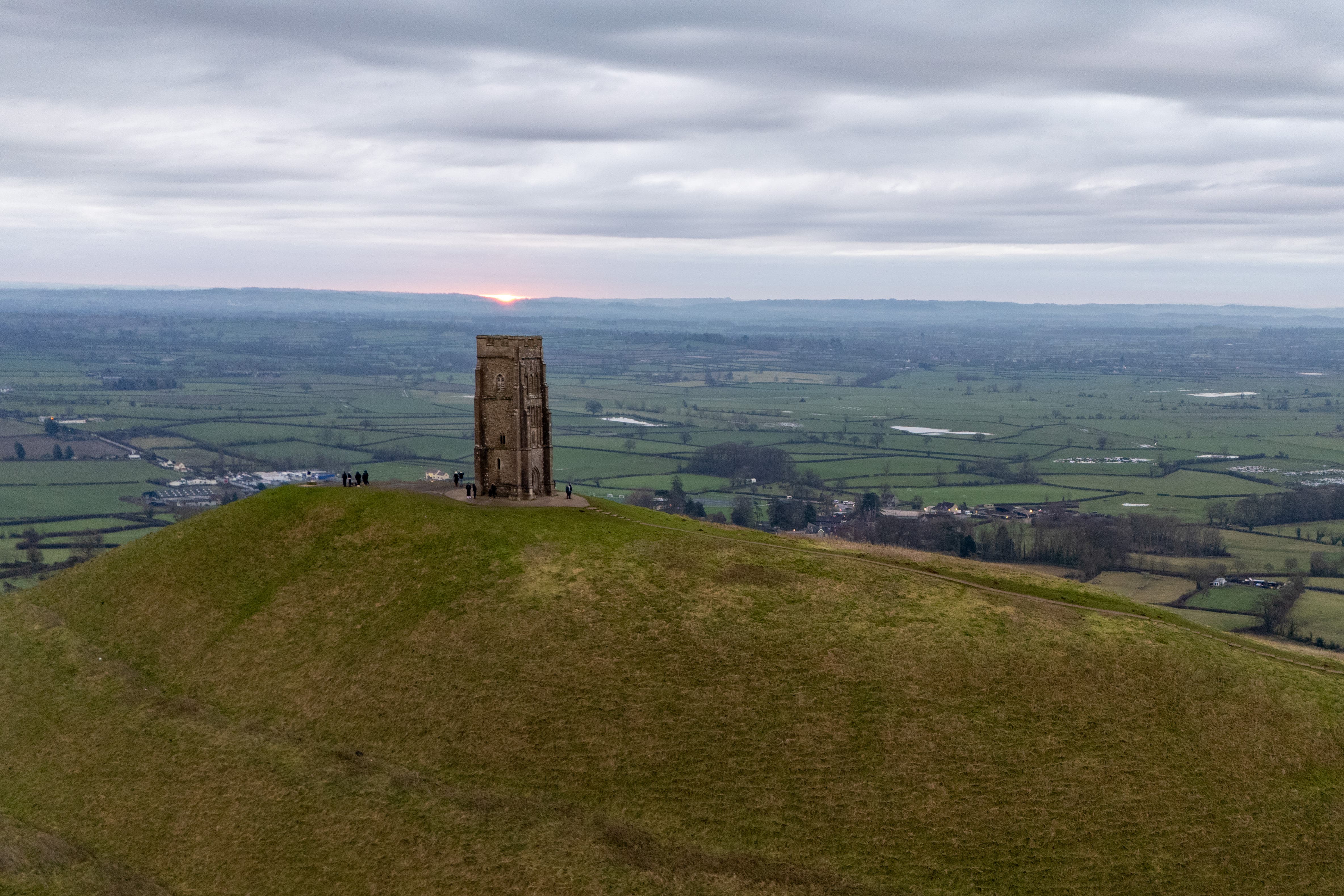 People watch the sun rise on Glastonbury Tor over the Somerset levels (Ben Birchall/PA)