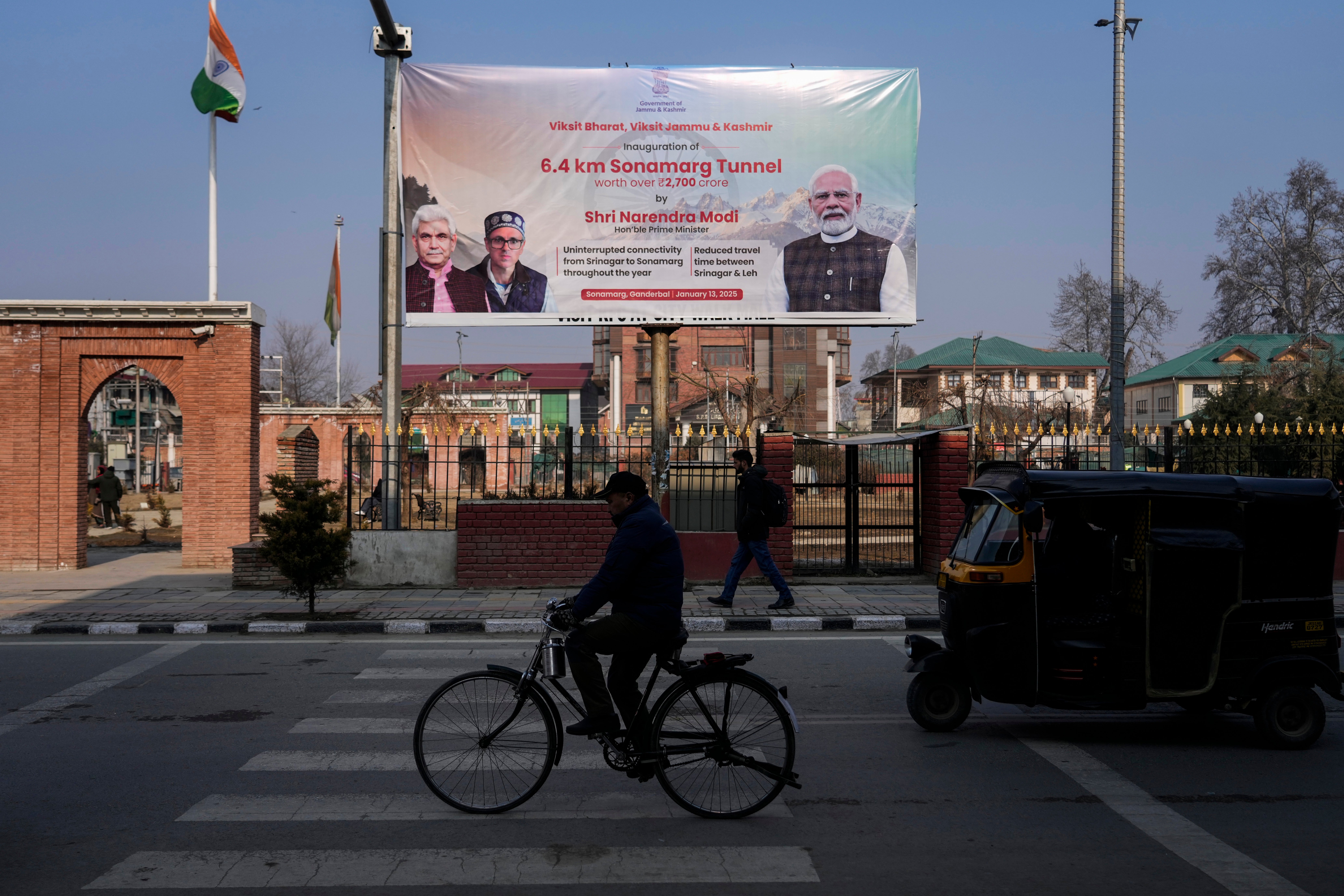 Traffic moves past a banner in Srinagar, welcoming the Indian Prime Minister Narendra Modi and other leaders to inaugurate a strategic tunnel project that connects Kashmir with Ladakh, Monday, 13 Jan 2025