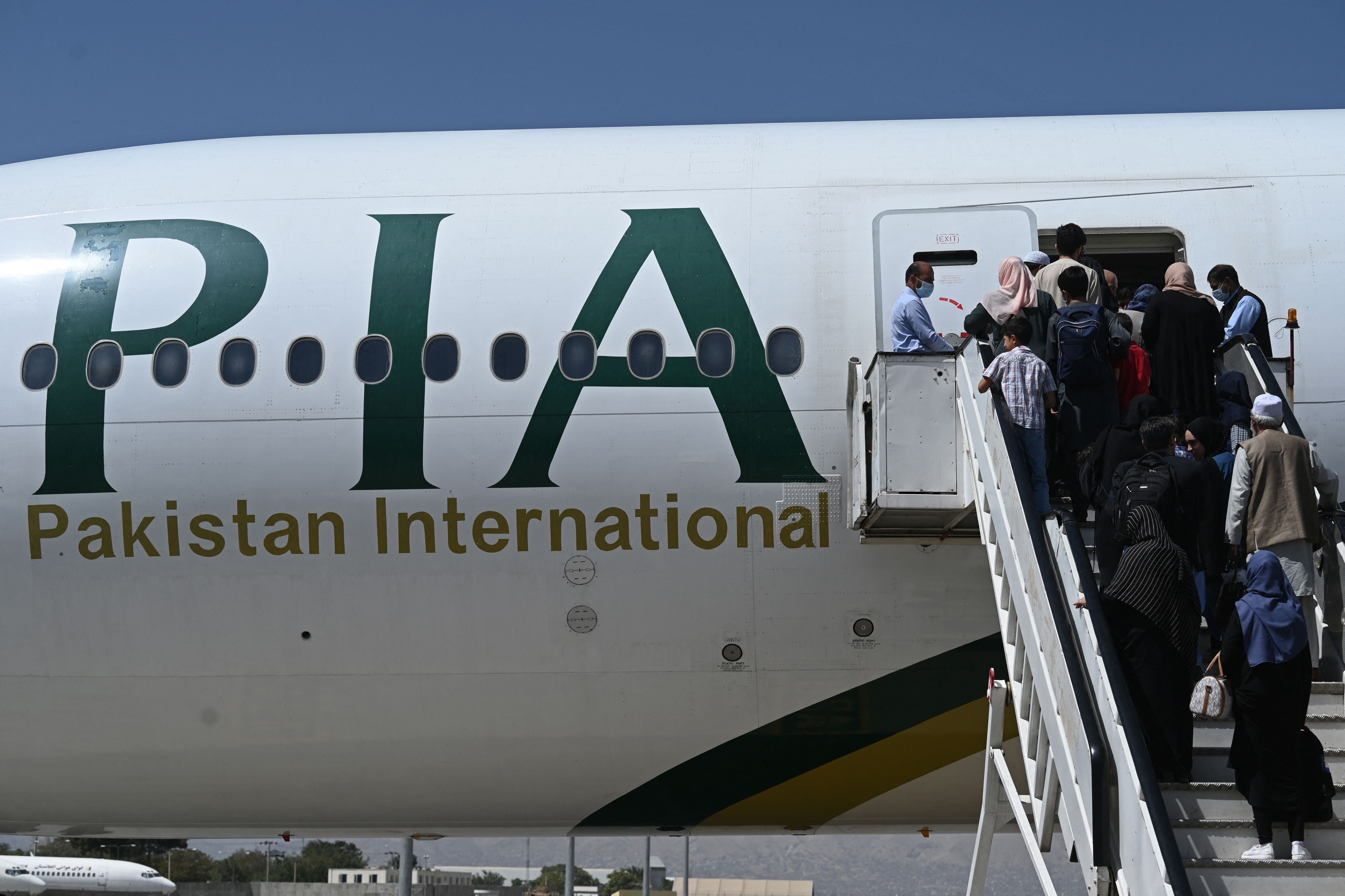 File. Passengers board a Pakistan International Airlines flight