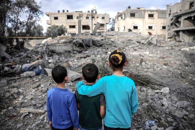 <p>Children stand amidst the rubble of a building hit by an Israeli air strike in Deir al-Balah in the centre of the Gaza Strip</p>